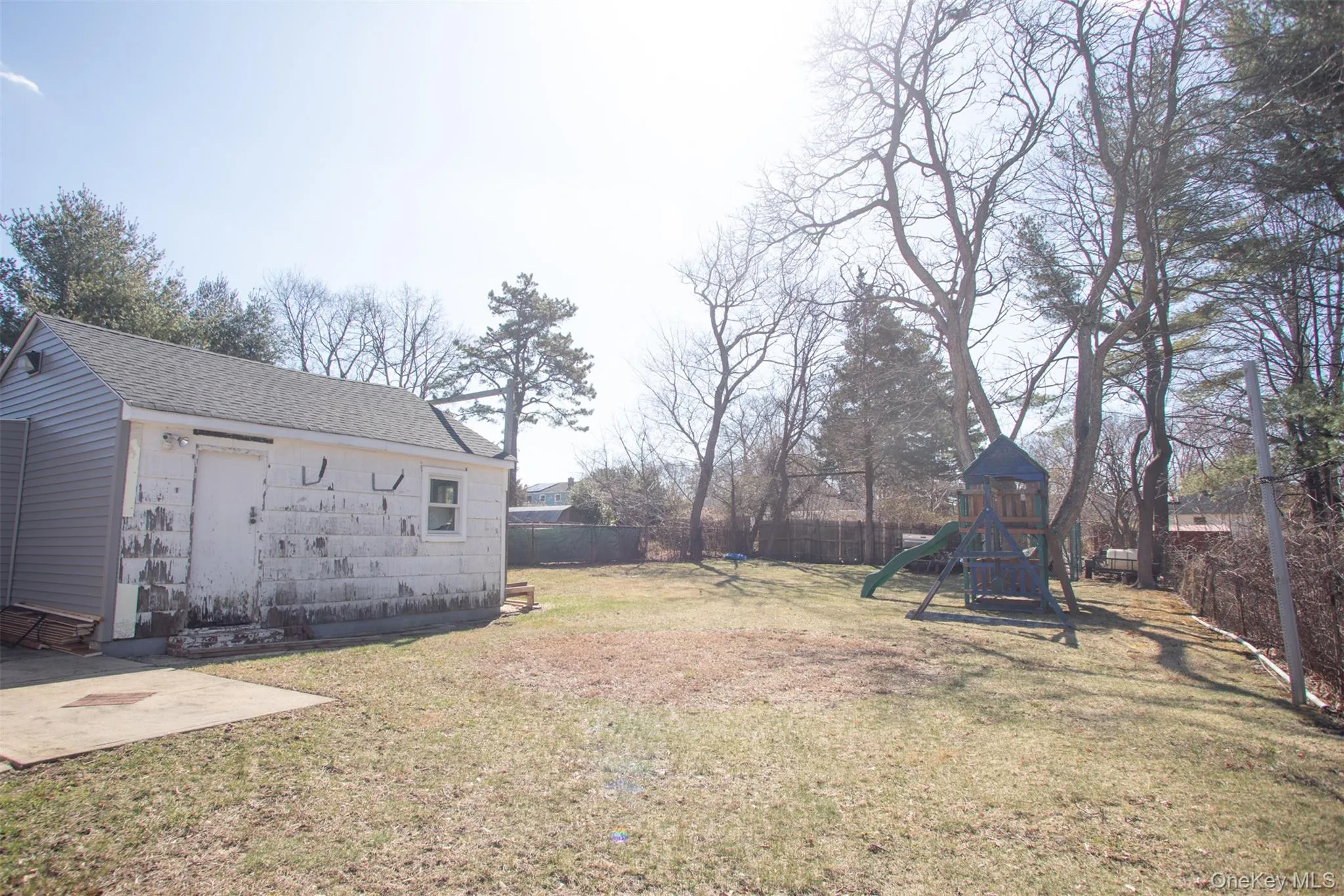 View of yard featuring a patio, an outbuilding, fence, and a playground View of yard featuring a patio, an outbuilding, fence, and a playground
