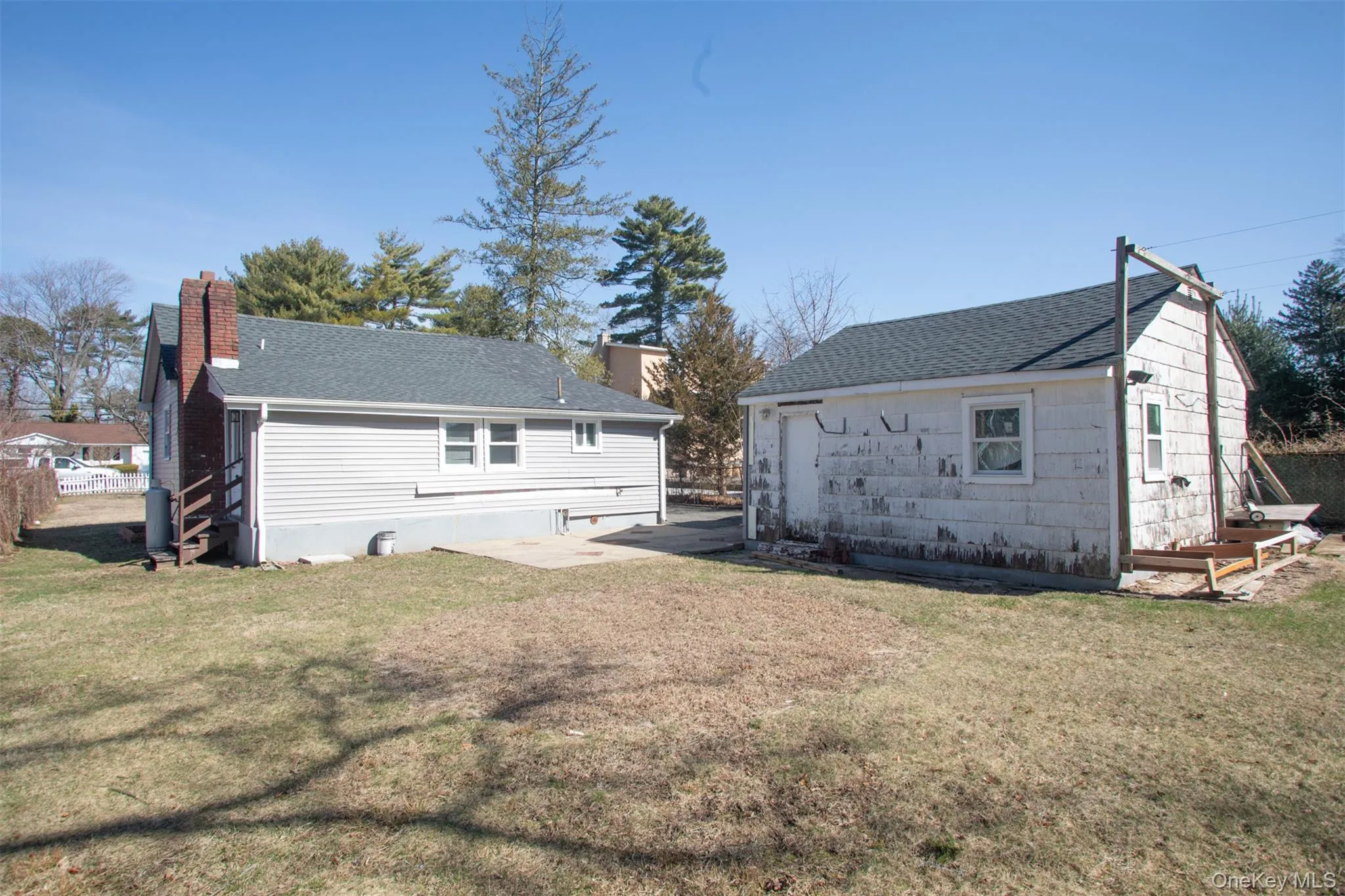 Back of property featuring roof with shingles and a lawn Back of property featuring roof with shingles and a lawn