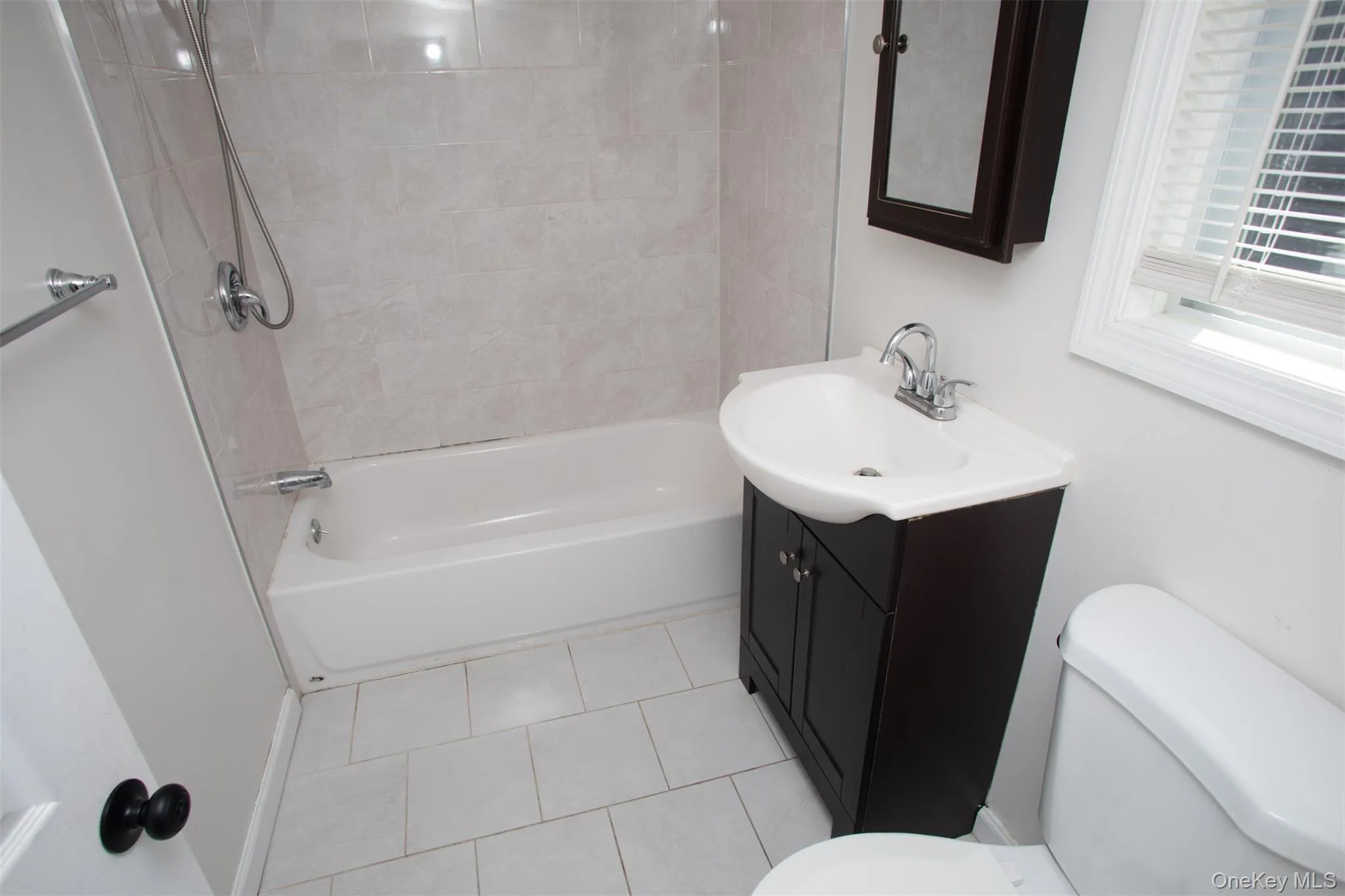 Full bathroom with bathing tub / shower combination, toilet, tile patterned flooring, and vanity Full bathroom with bathing tub / shower combination, toilet, tile patterned flooring, and vanity