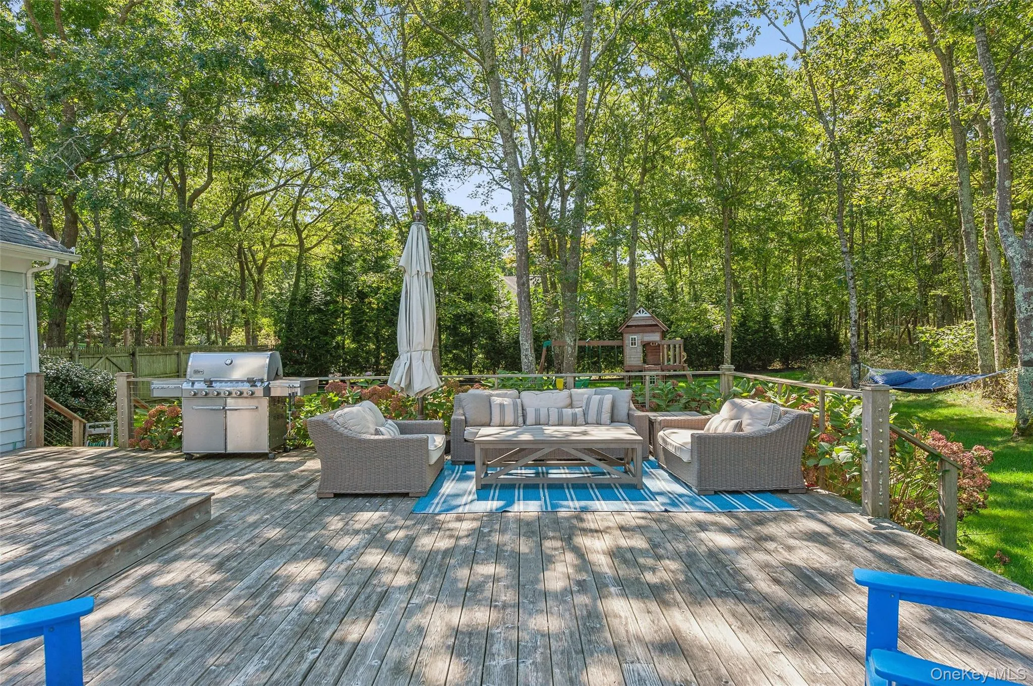 Wooden terrace featuring a grill and an outdoor hangout area Wooden terrace featuring a grill and an outdoor hangout area
