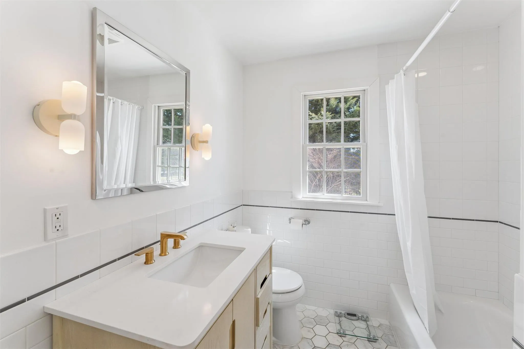 Full bathroom with toilet, vanity, shower / bath combo, wainscoting, and tile walls Full bathroom with toilet, vanity, shower / bath combo, wainscoting, and tile walls