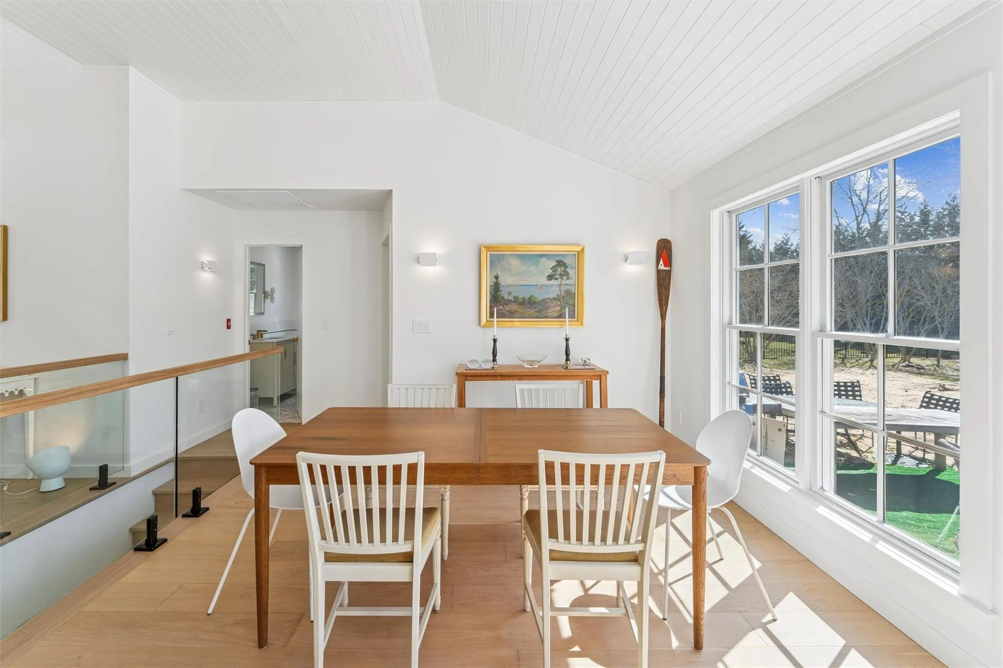 Dining space with light wood-style floors and vaulted ceiling Dining space with light wood-style floors and vaulted ceiling