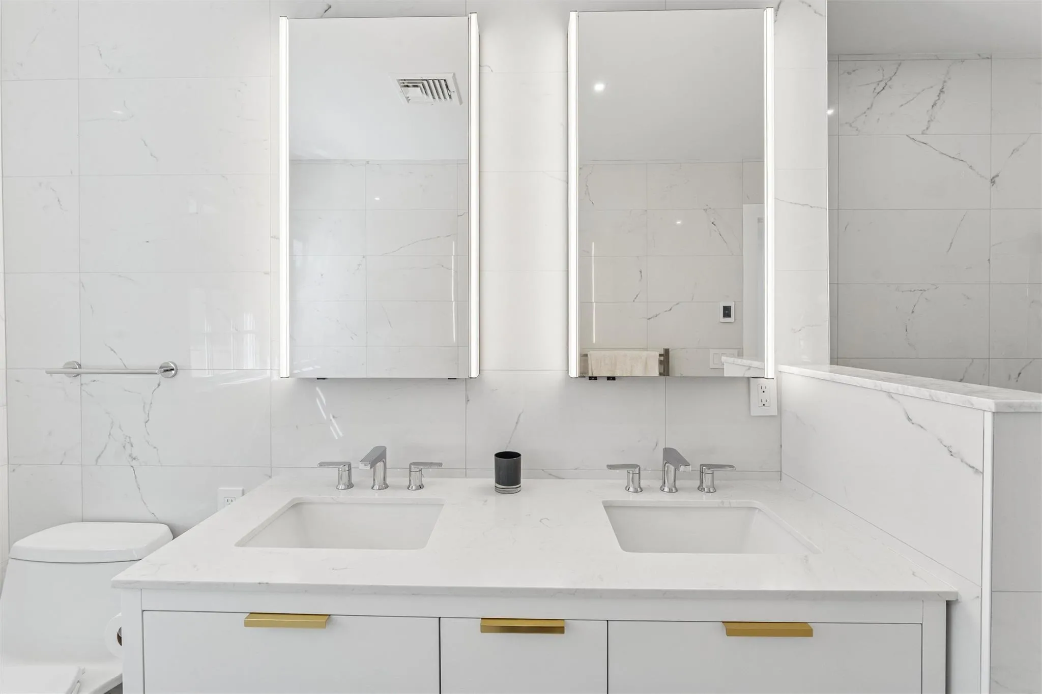 Bathroom with double vanity, visible vents, a sink, and toilet Bathroom with double vanity, visible vents, a sink, and toilet