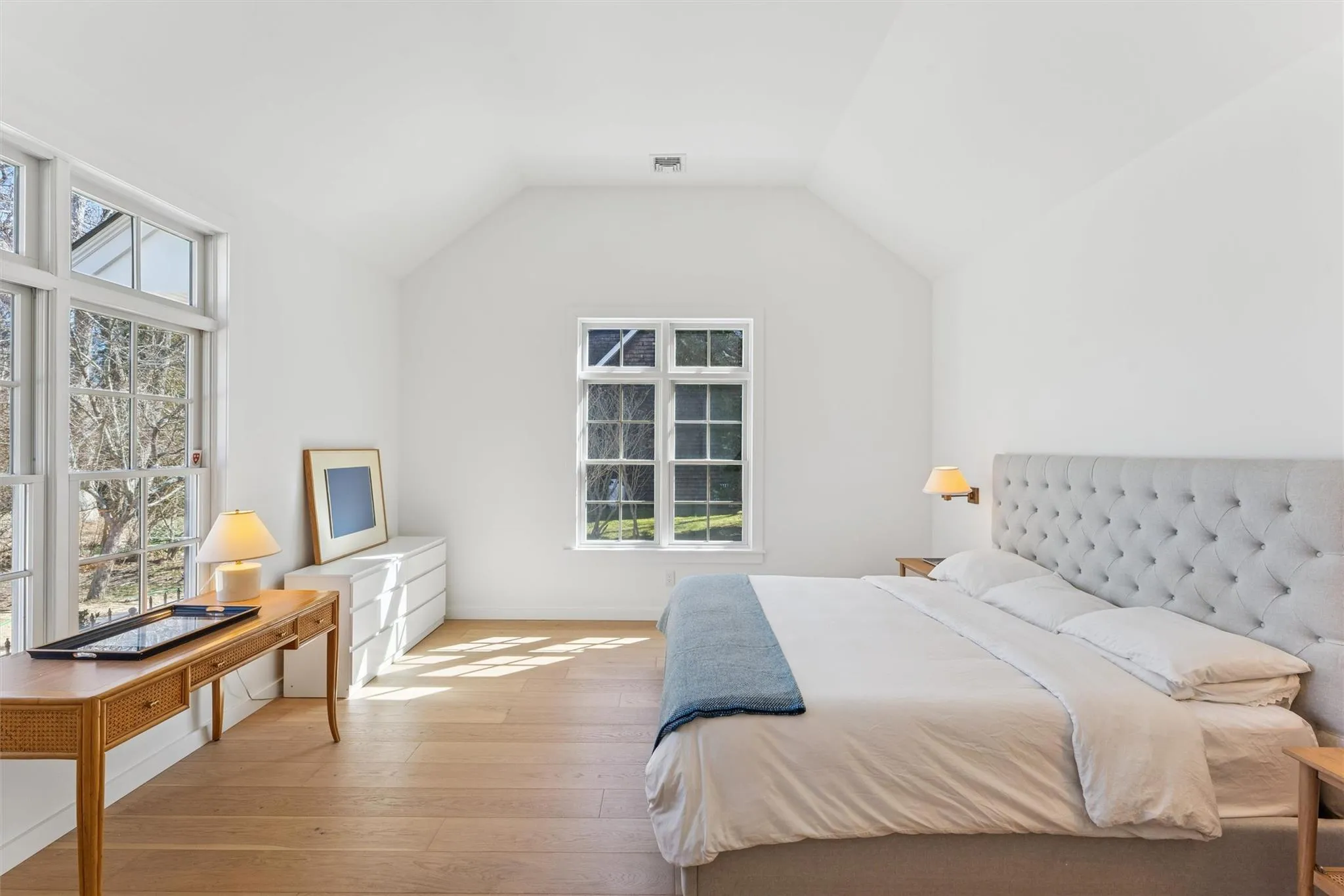 Bedroom featuring lofted ceiling, light wood finished floors, and visible vents Bedroom featuring lofted ceiling, light wood finished floors, and visible vents