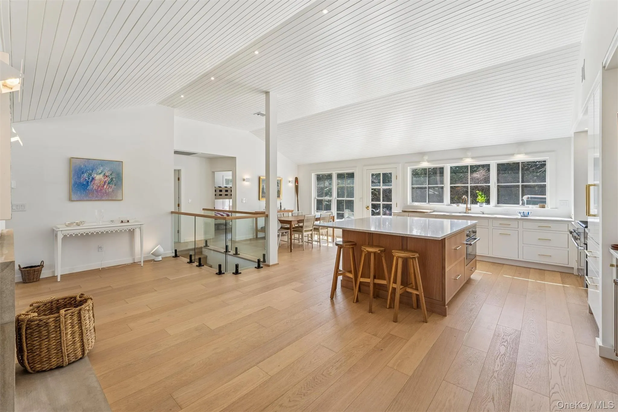 Kitchen with light countertops, a kitchen island, a kitchen breakfast bar, light wood-type flooring, and lofted ceiling Kitchen with light countertops, a kitchen island, a kitchen breakfast bar, light wood-type flooring, and lofted ceiling