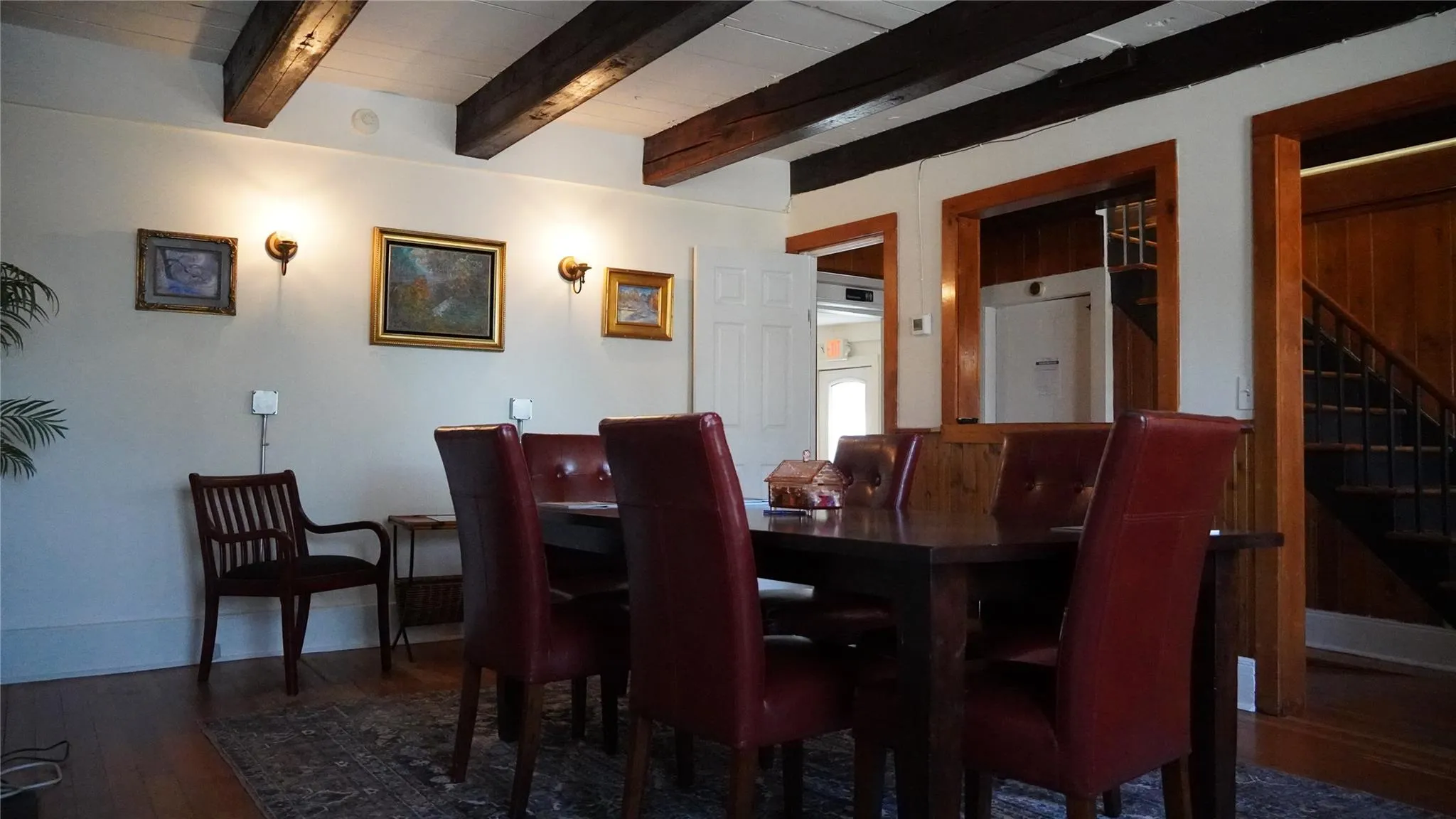 Dining space with wood finished floors, stairway, and beam ceiling Dining space with wood finished floors, stairway, and beam ceiling