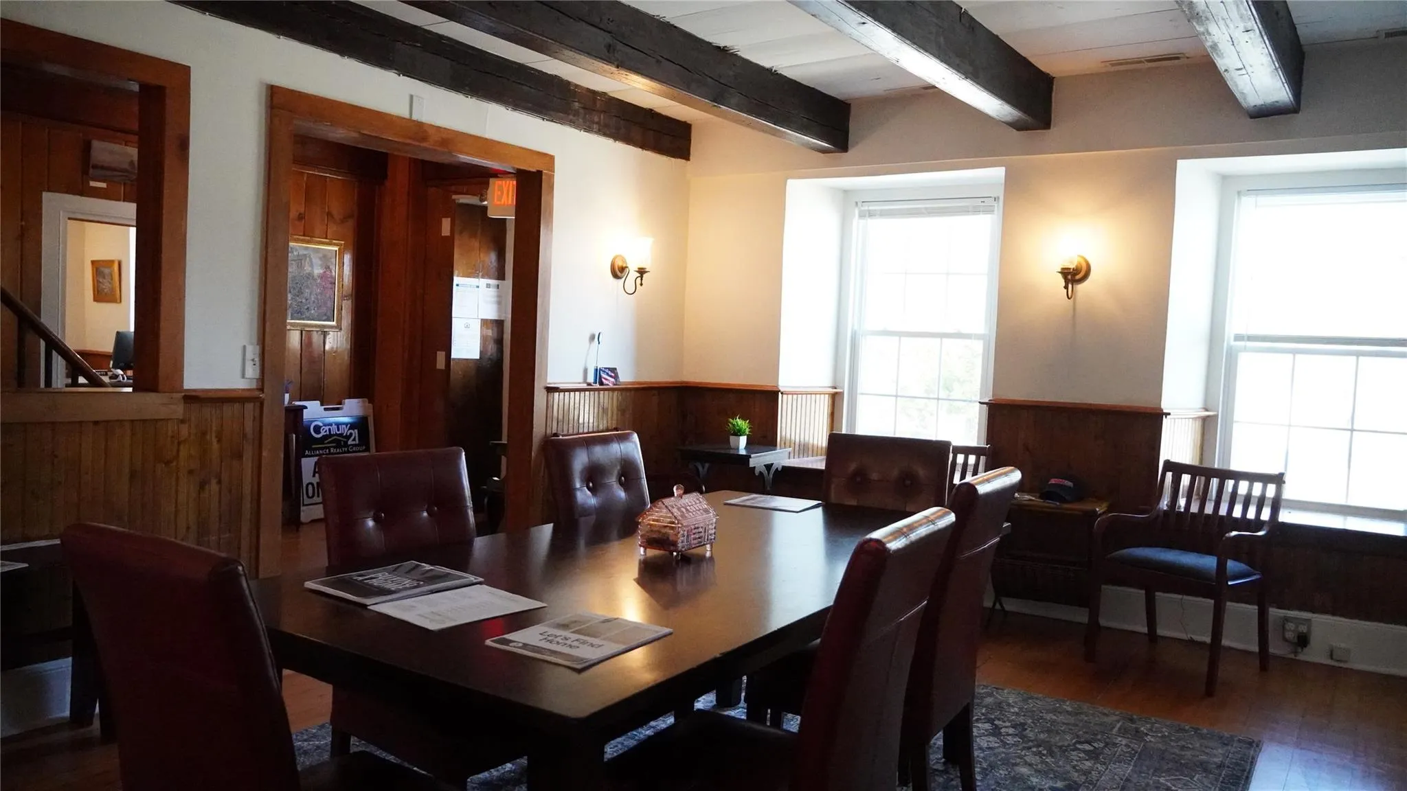 Dining room featuring wooden walls, wood finished floors, wainscoting, and beam ceiling Dining room featuring wooden walls, wood finished floors, wainscoting, and beam ceiling