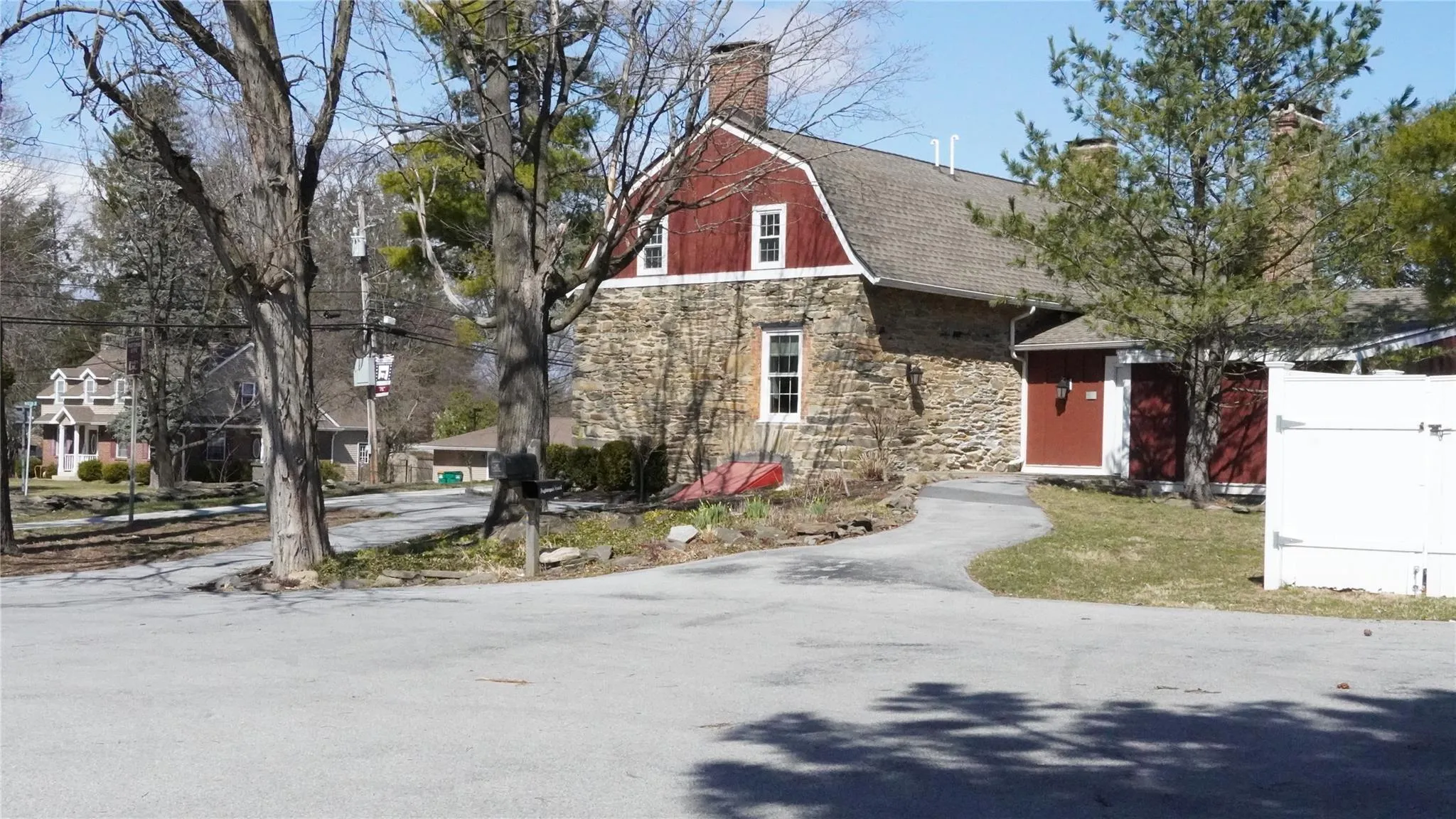 Dutch colonial featuring stone siding, a gambrel roof, roof with shingles, and a chimney Dutch colonial featuring stone siding, a gambrel roof, roof with shingles, and a chimney