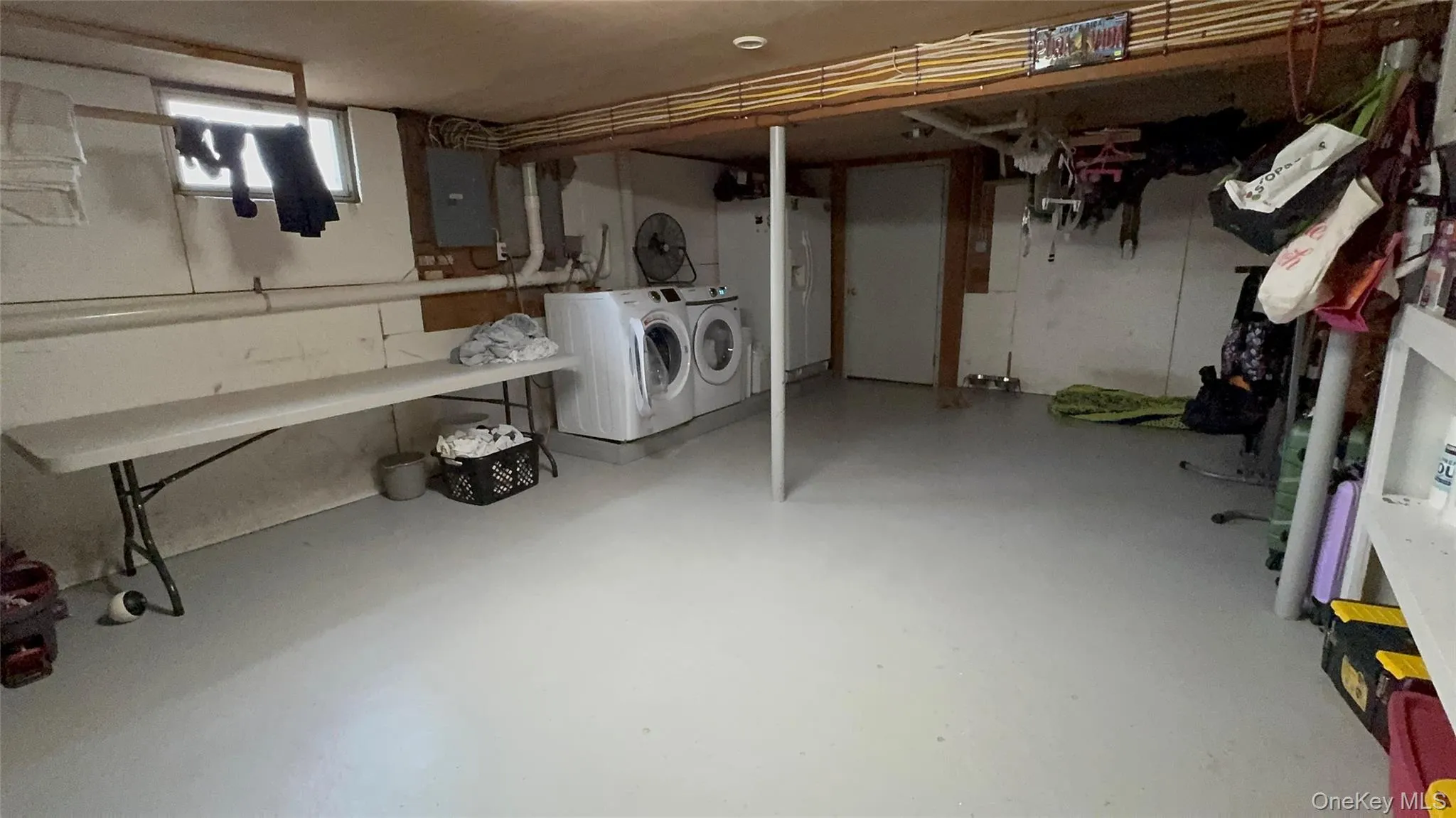 Below grade area featuring washing machine and clothes dryer and electric panel
