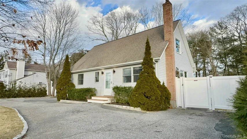 Cape cod home with a chimney, a gate, fence, and roof with shingles