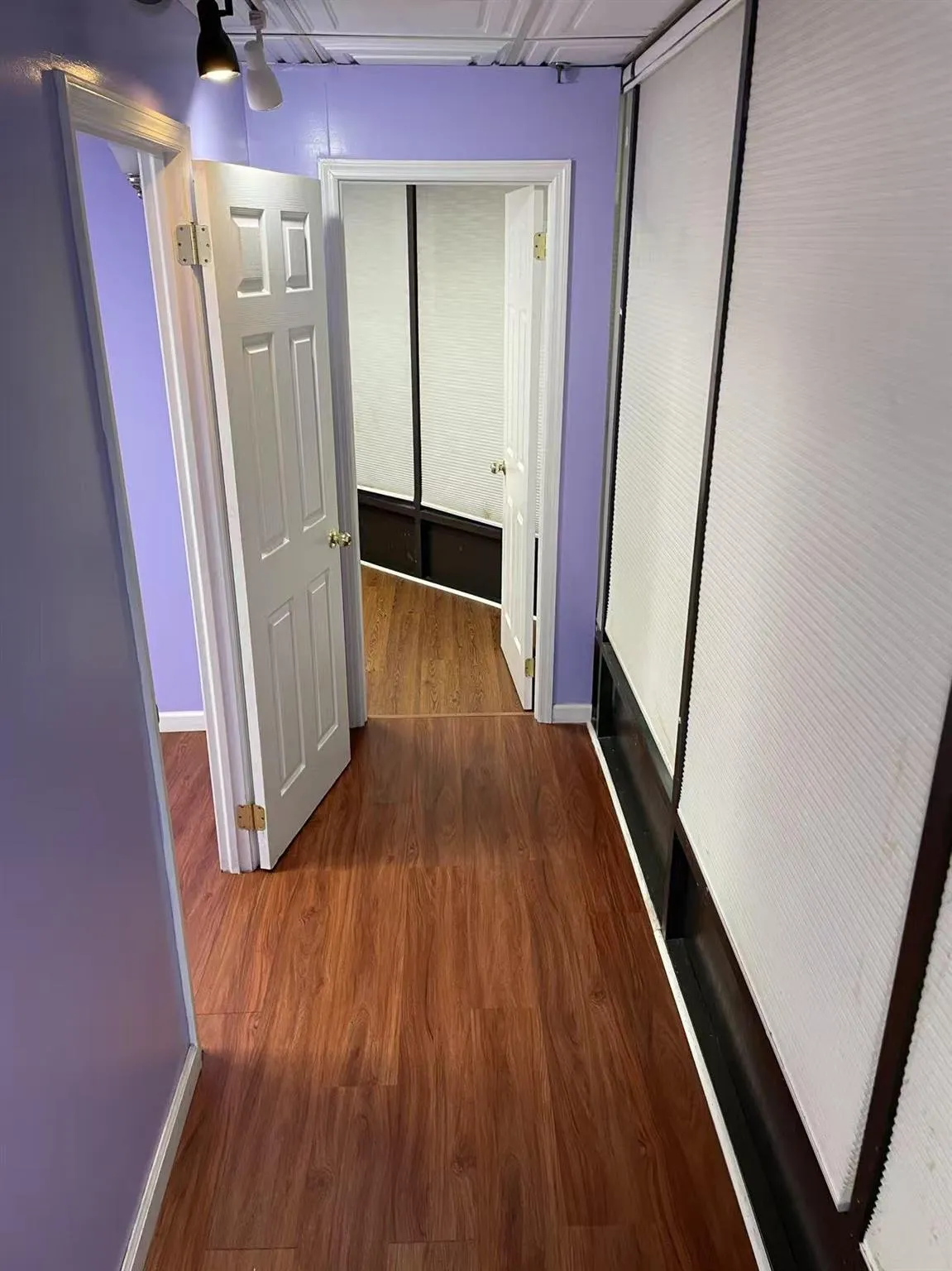 Hallway with baseboards and wood finished floors Hallway with baseboards and wood finished floors