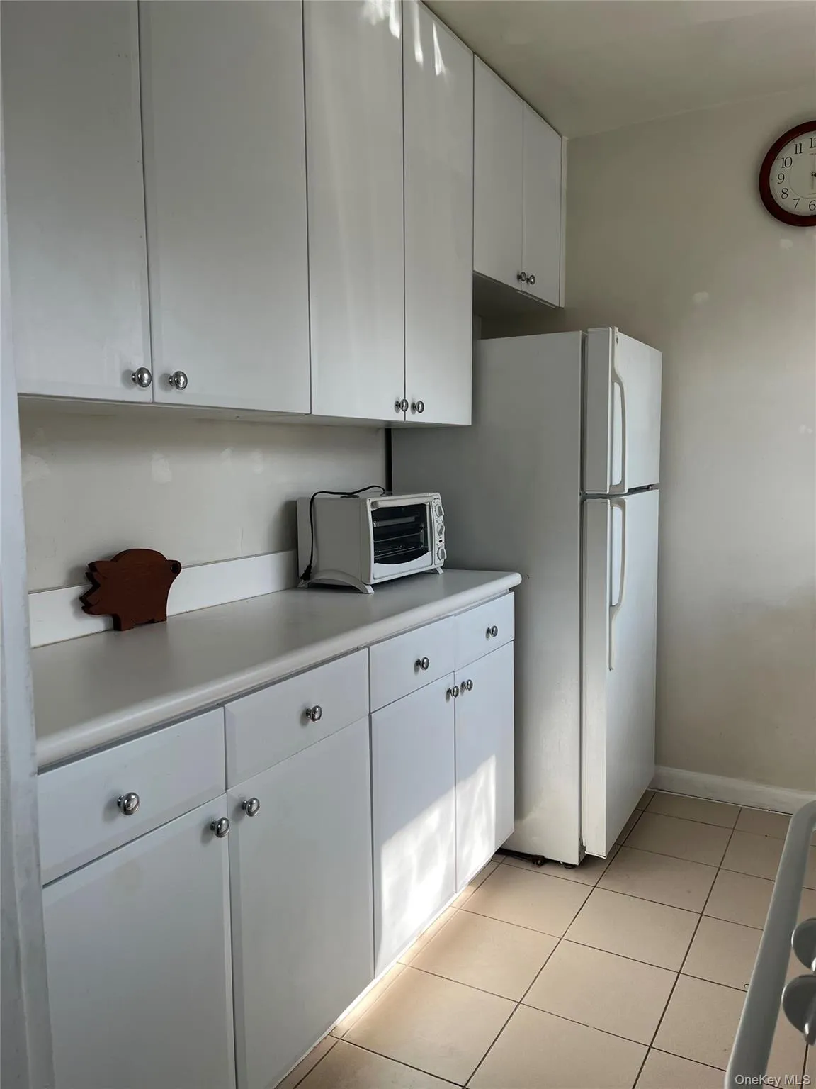 Kitchen with white cabinetry, light countertops, a toaster, and light tile patterned floors Kitchen with white cabinetry, light countertops, a toaster, and light tile patterned floors