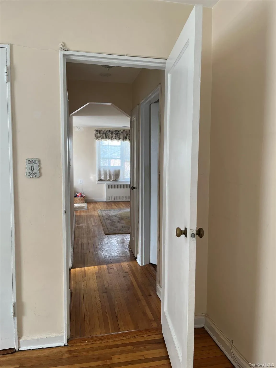 Corridor featuring radiator, baseboards, and hardwood / wood-style flooring Corridor featuring radiator, baseboards, and hardwood / wood-style flooring