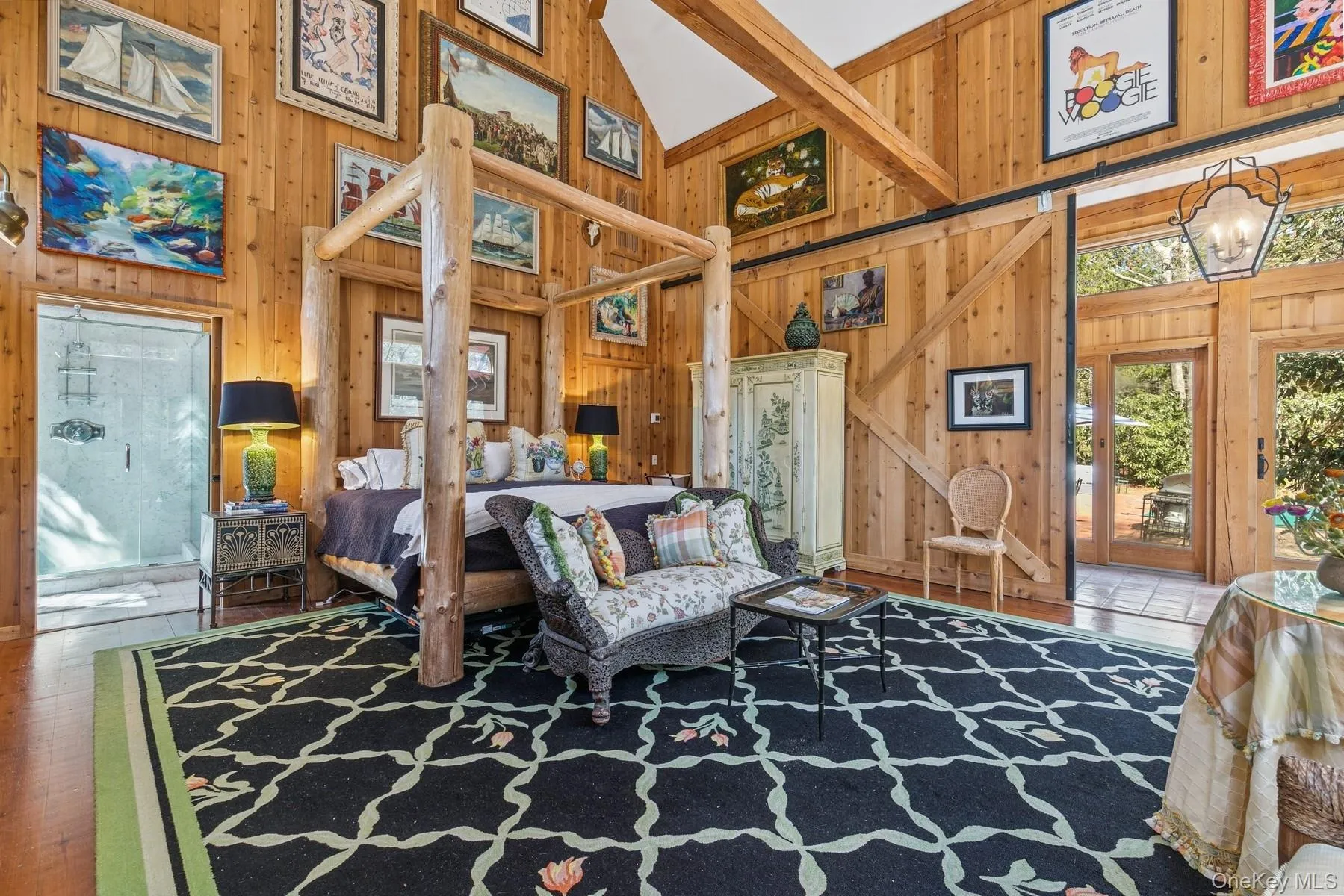 Bedroom with high vaulted ceiling, wood finished floors, an inviting chandelier, wood walls, and access to outside Bedroom with high vaulted ceiling, wood finished floors, an inviting chandelier, wood walls, and access to outside