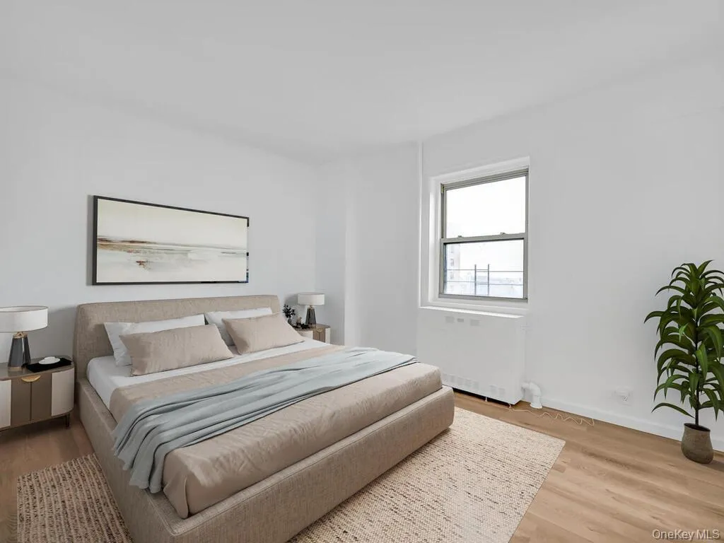 Bedroom featuring baseboards, wood finished floors, and radiator Bedroom featuring baseboards, wood finished floors, and radiator