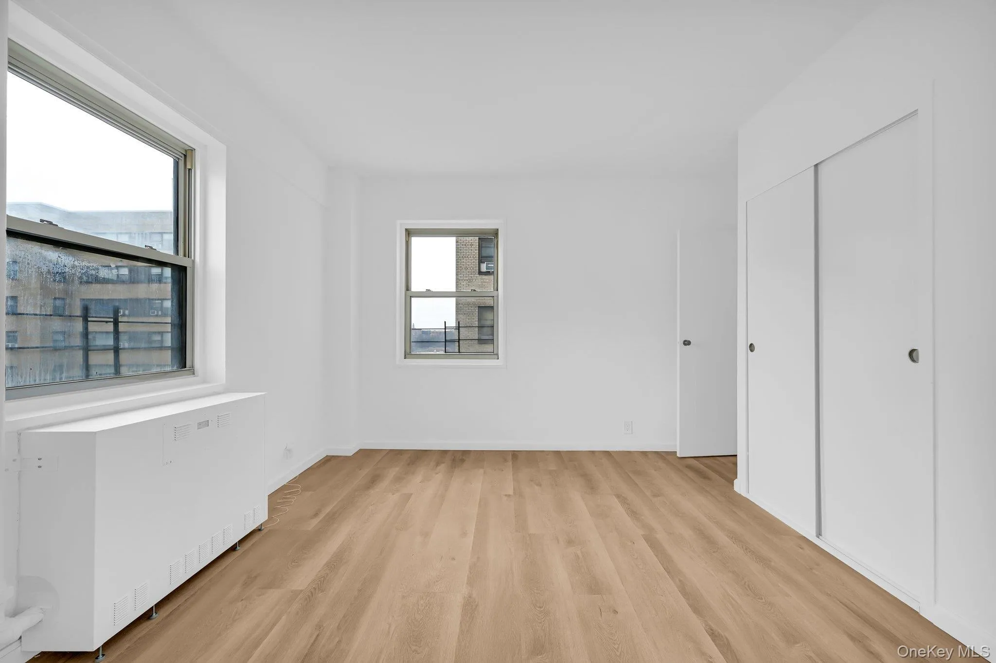 bedroom 1 with light wood-type flooring, a closet, and radiator heating unit bedroom 1 with light wood-type flooring, a closet, and radiator heating unit