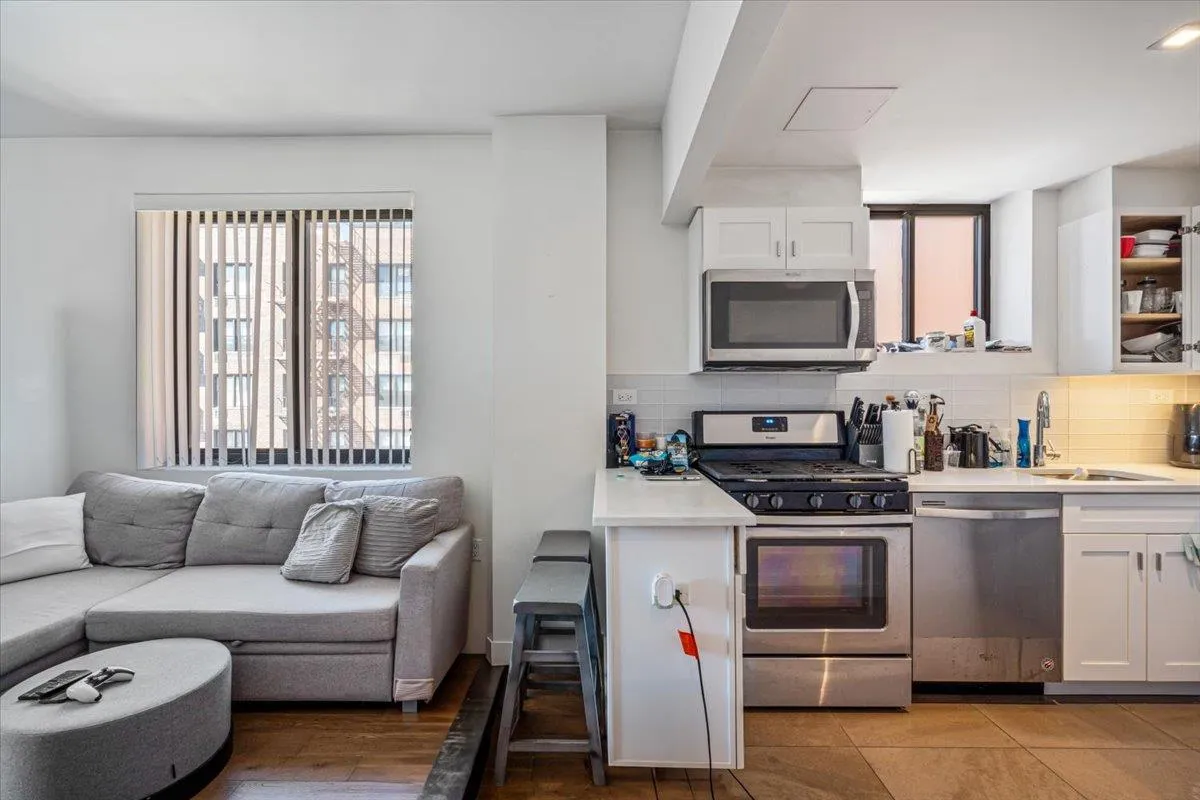 Kitchen featuring tasteful backsplash, appliances with stainless steel finishes, a sink, and white cabinetry Kitchen featuring tasteful backsplash, appliances with stainless steel finishes, a sink, and white cabinetry