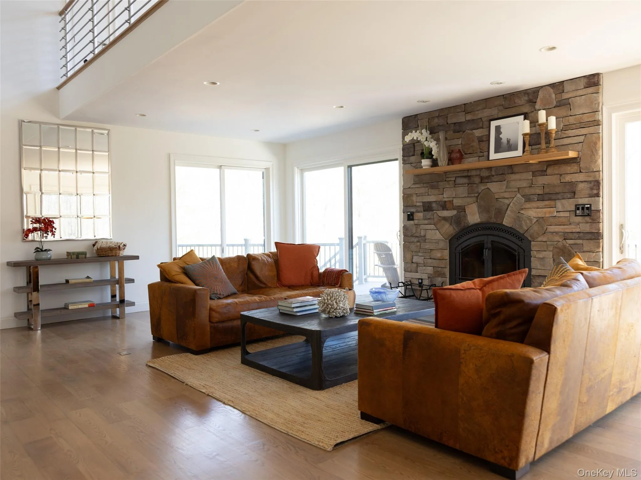 Living room featuring recessed lighting, wood finished floors, and a fireplace Living room featuring recessed lighting, wood finished floors, and a fireplace