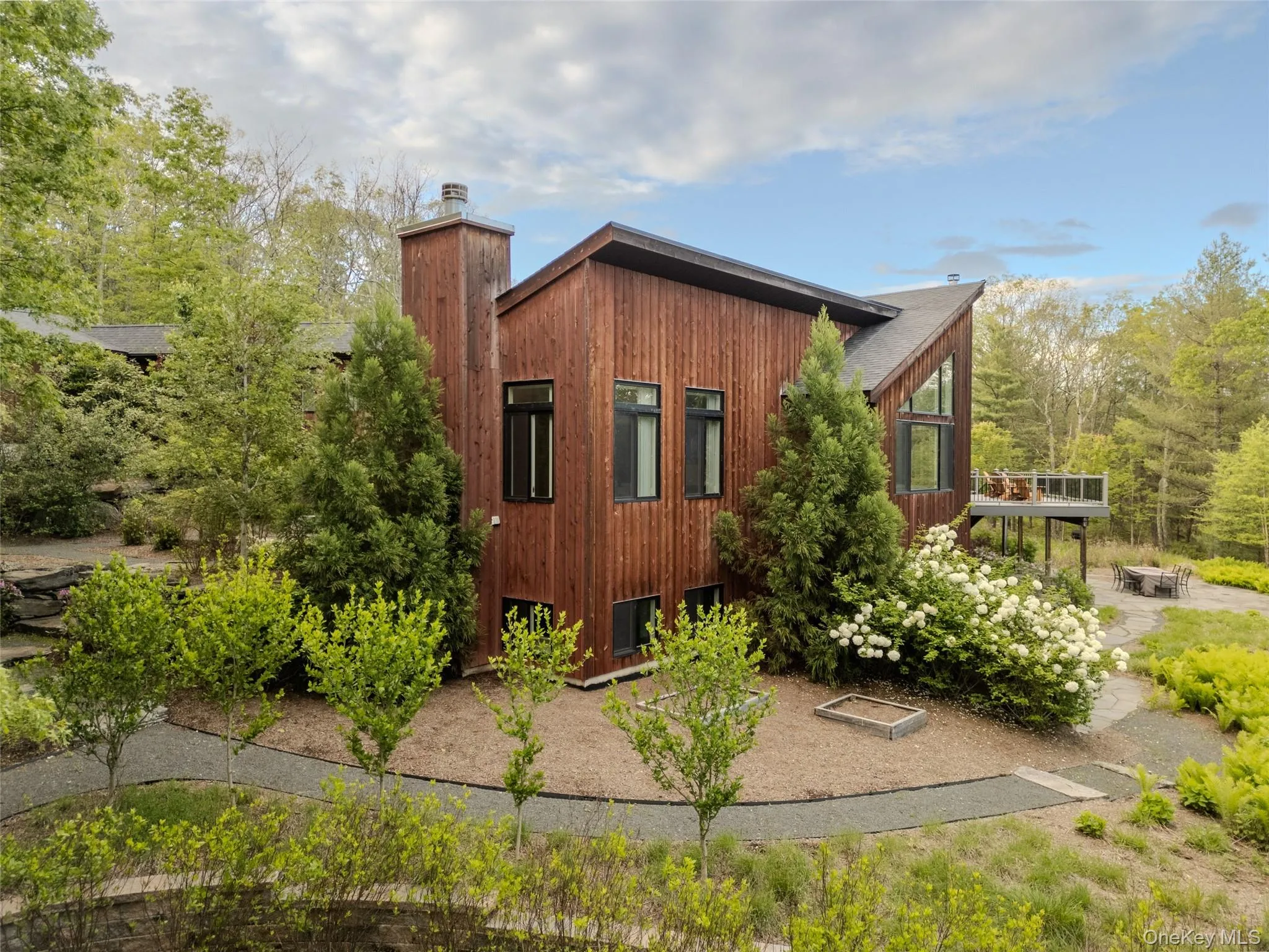 View of side of home with an outdoor fire pit and a chimney View of side of home with an outdoor fire pit and a chimney
