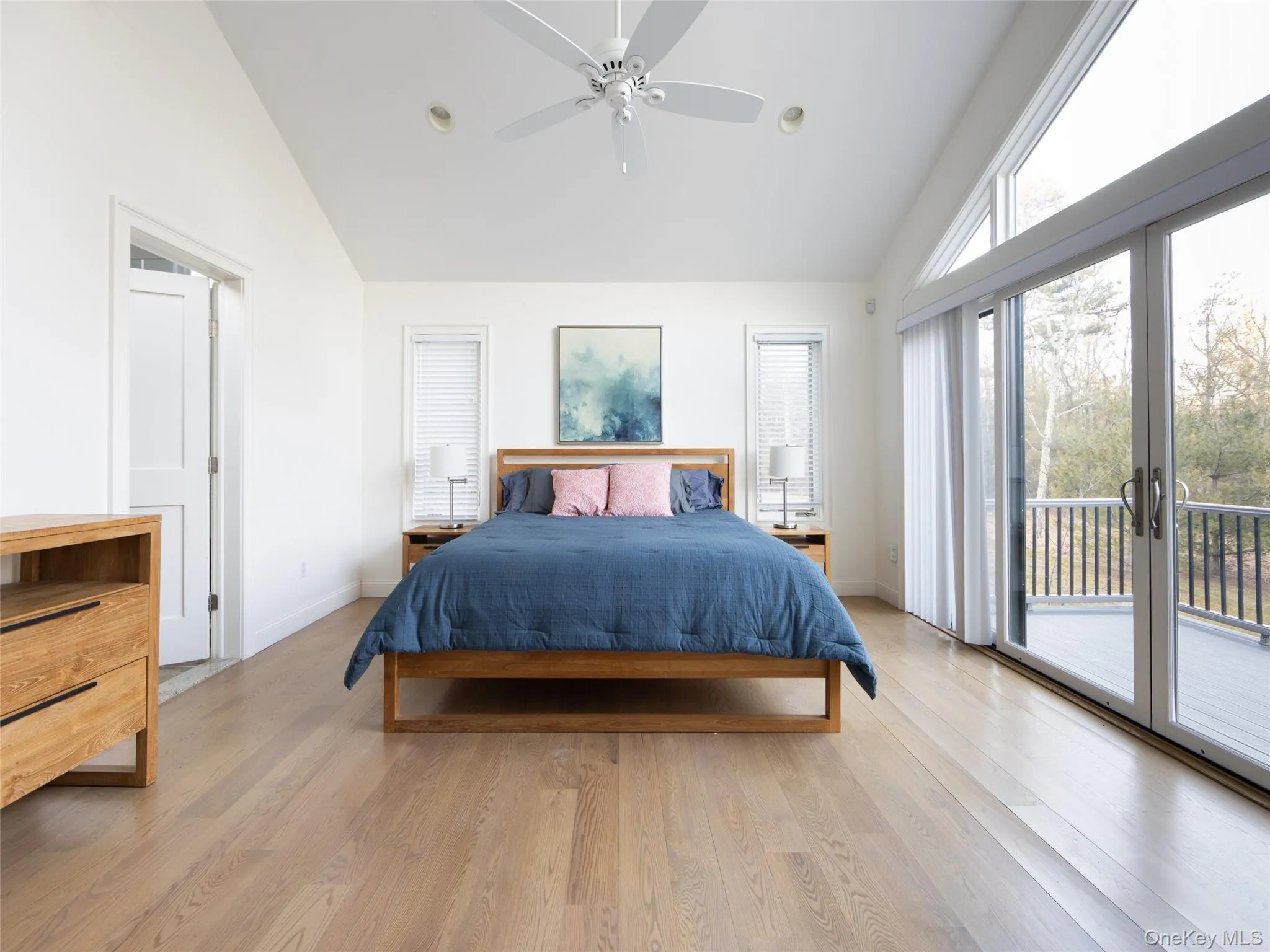 Bedroom with high vaulted ceiling, light wood-type flooring, access to exterior, and baseboards Bedroom with high vaulted ceiling, light wood-type flooring, access to exterior, and baseboards