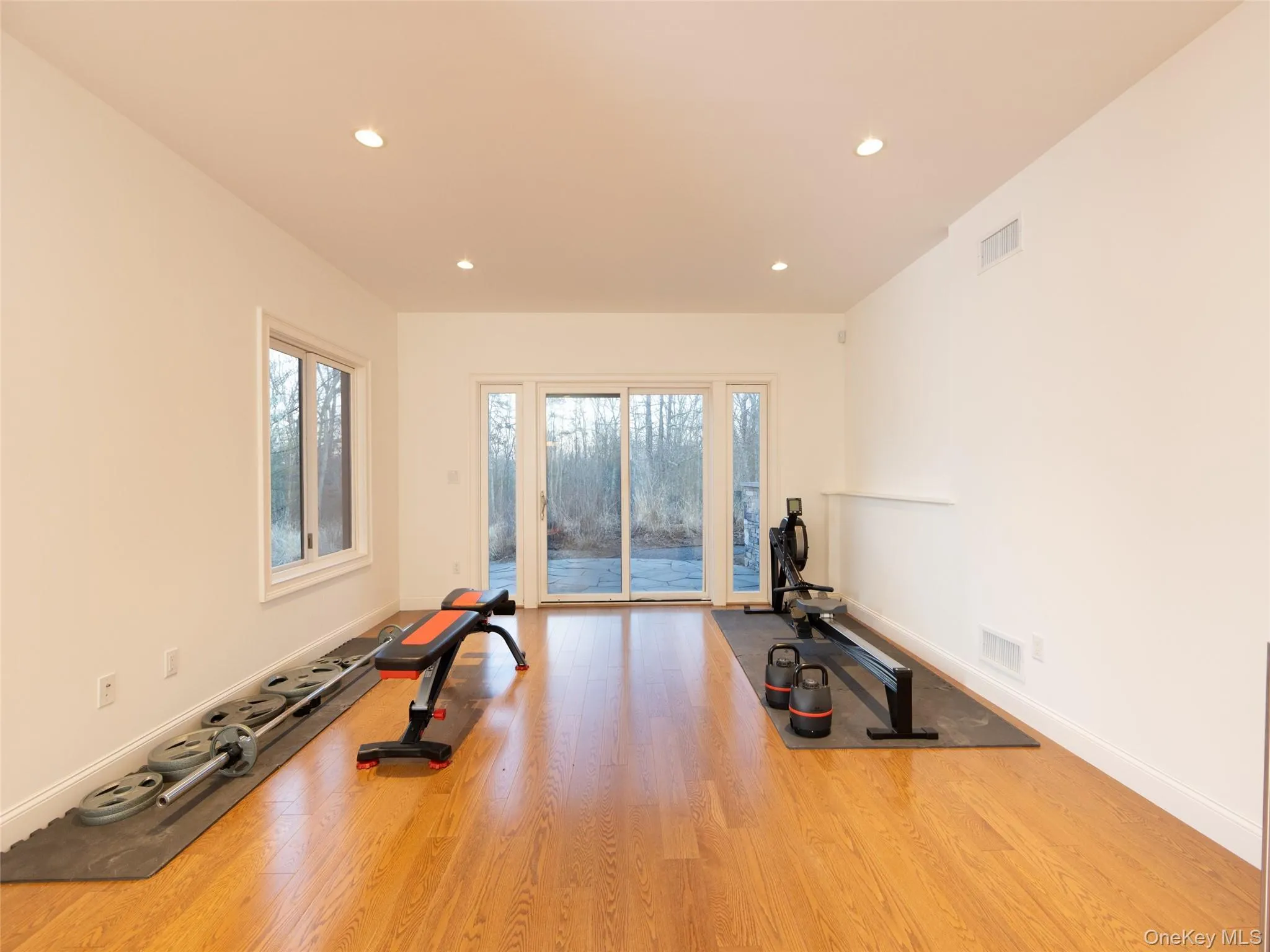 Exercise room with recessed lighting, visible vents, baseboards, and wood finished floors Exercise room with recessed lighting, visible vents, baseboards, and wood finished floors