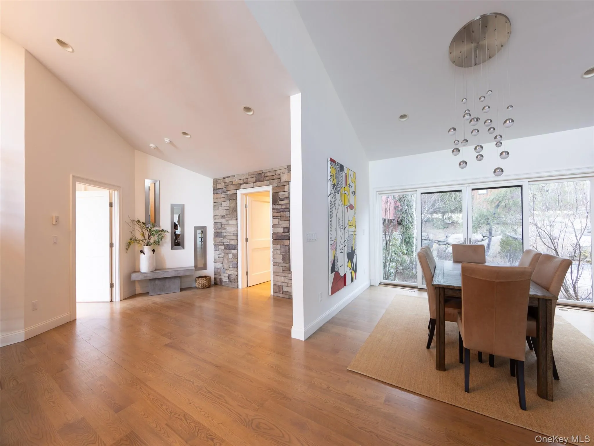 Dining area with high vaulted ceiling, light wood finished floors, and baseboards Dining area with high vaulted ceiling, light wood finished floors, and baseboards