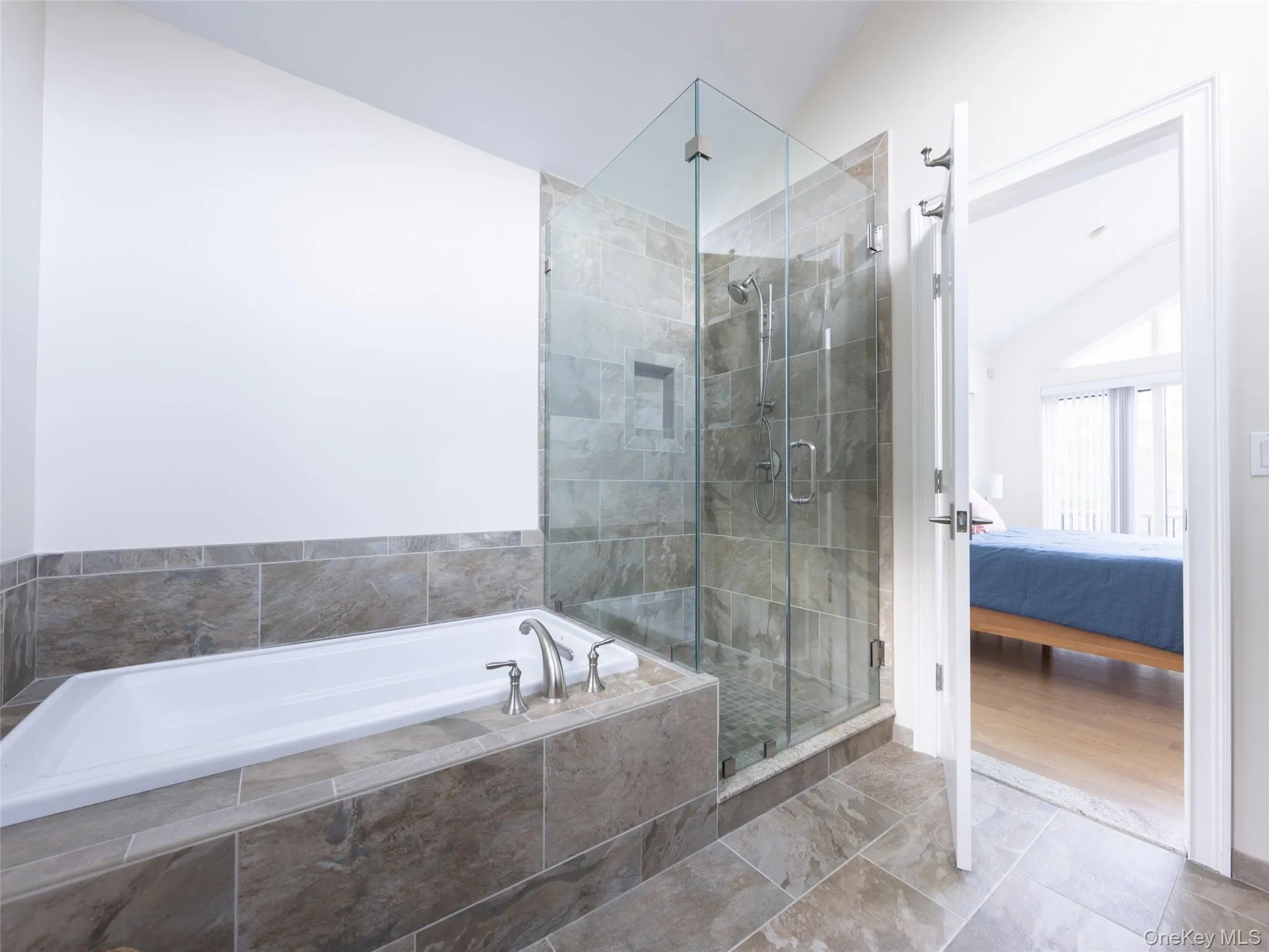 Ensuite bathroom with a bath, a shower stall, connected bathroom, and lofted ceiling Ensuite bathroom with a bath, a shower stall, connected bathroom, and lofted ceiling