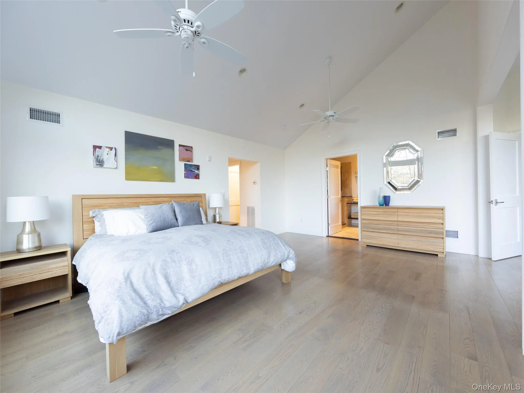 Bedroom featuring wood finished floors, a ceiling fan, and visible vents Bedroom featuring wood finished floors, a ceiling fan, and visible vents