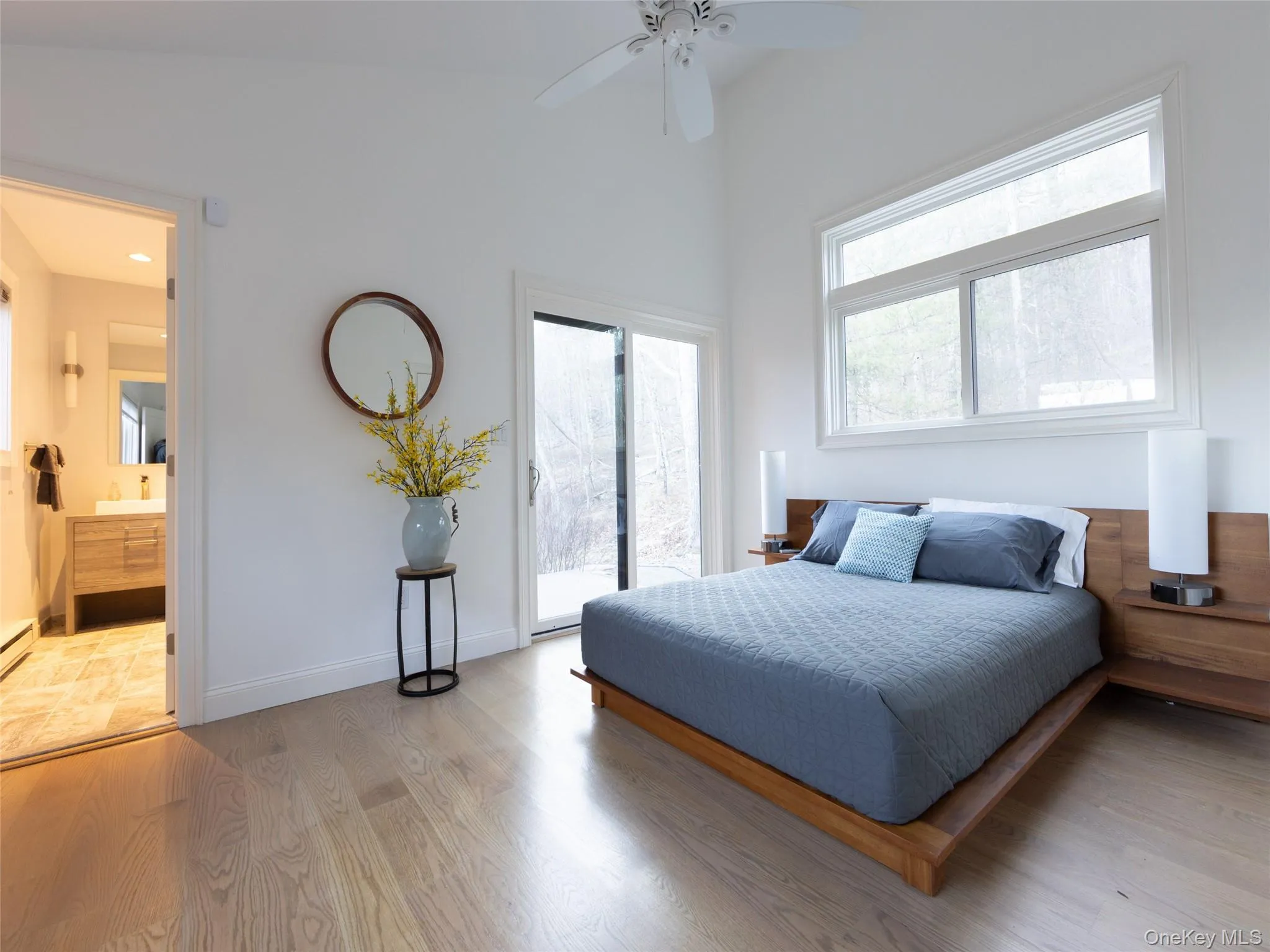 Bedroom featuring access to outside, baseboards, light wood-style flooring, a ceiling fan, and connected bathroom Bedroom featuring access to outside, baseboards, light wood-style flooring, a ceiling fan, and connected bathroom