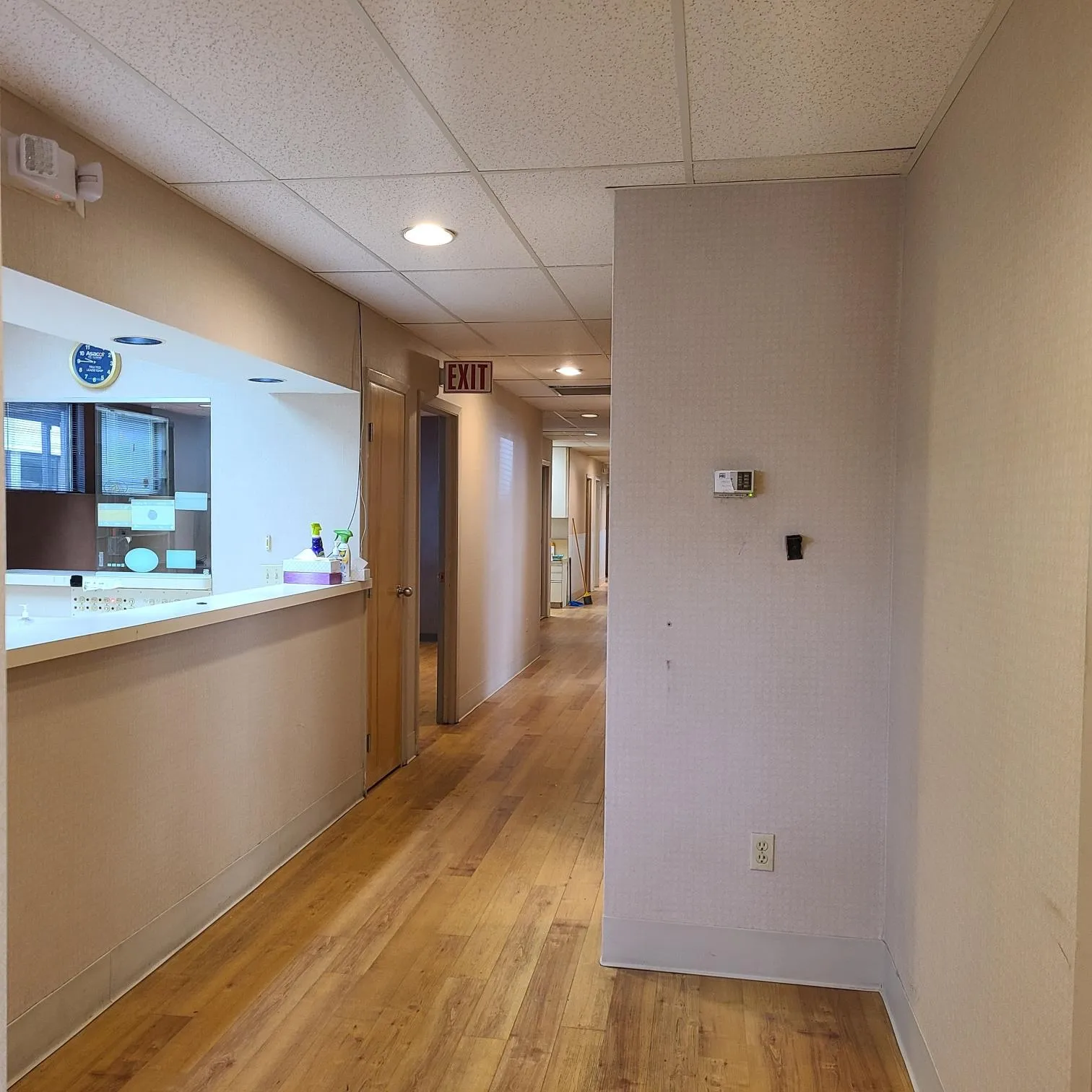 Hall with baseboards, light wood-style flooring, and a paneled ceiling Hall with baseboards, light wood-style flooring, and a paneled ceiling