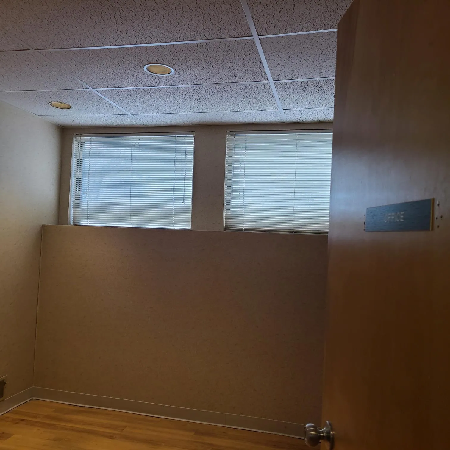 Empty room featuring baseboards, wood finished floors, and a drop ceiling Empty room featuring baseboards, wood finished floors, and a drop ceiling