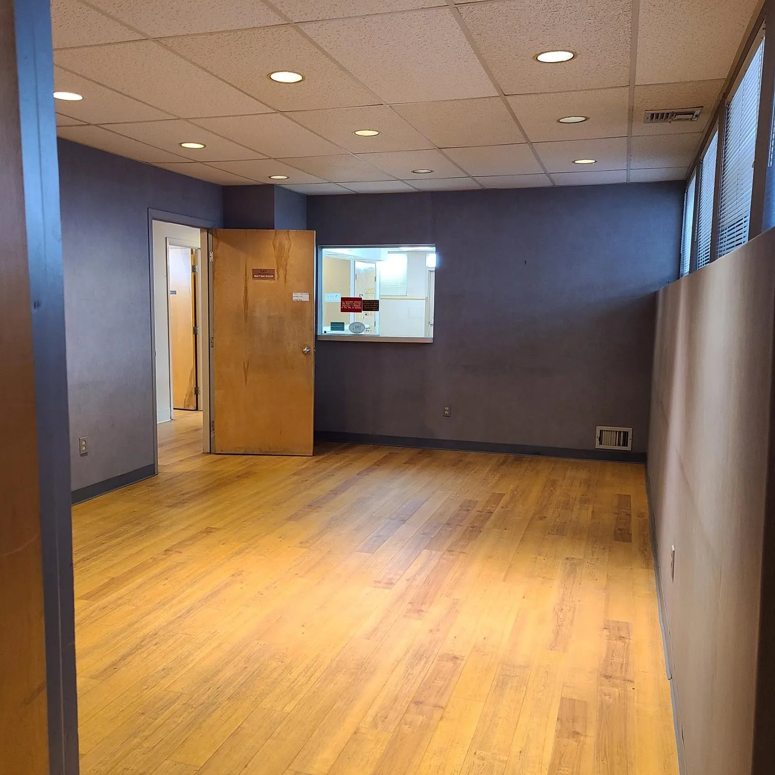 Unfurnished room featuring a paneled ceiling, wood finished floors, baseboards, and visible vents Unfurnished room featuring a paneled ceiling, wood finished floors, baseboards, and visible vents