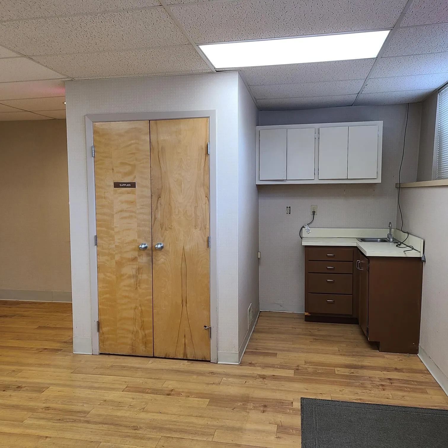 Kitchen featuring light countertops, a paneled ceiling, and light wood finished floors Kitchen featuring light countertops, a paneled ceiling, and light wood finished floors