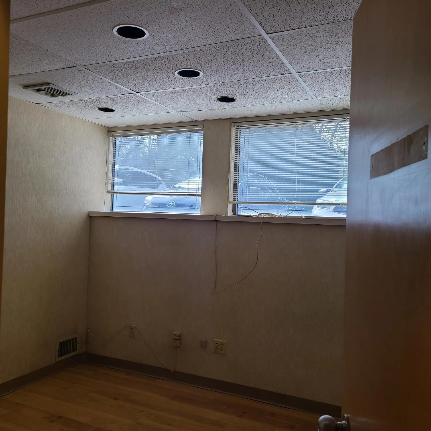 Empty room with visible vents, wood finished floors, and a paneled ceiling Empty room with visible vents, wood finished floors, and a paneled ceiling