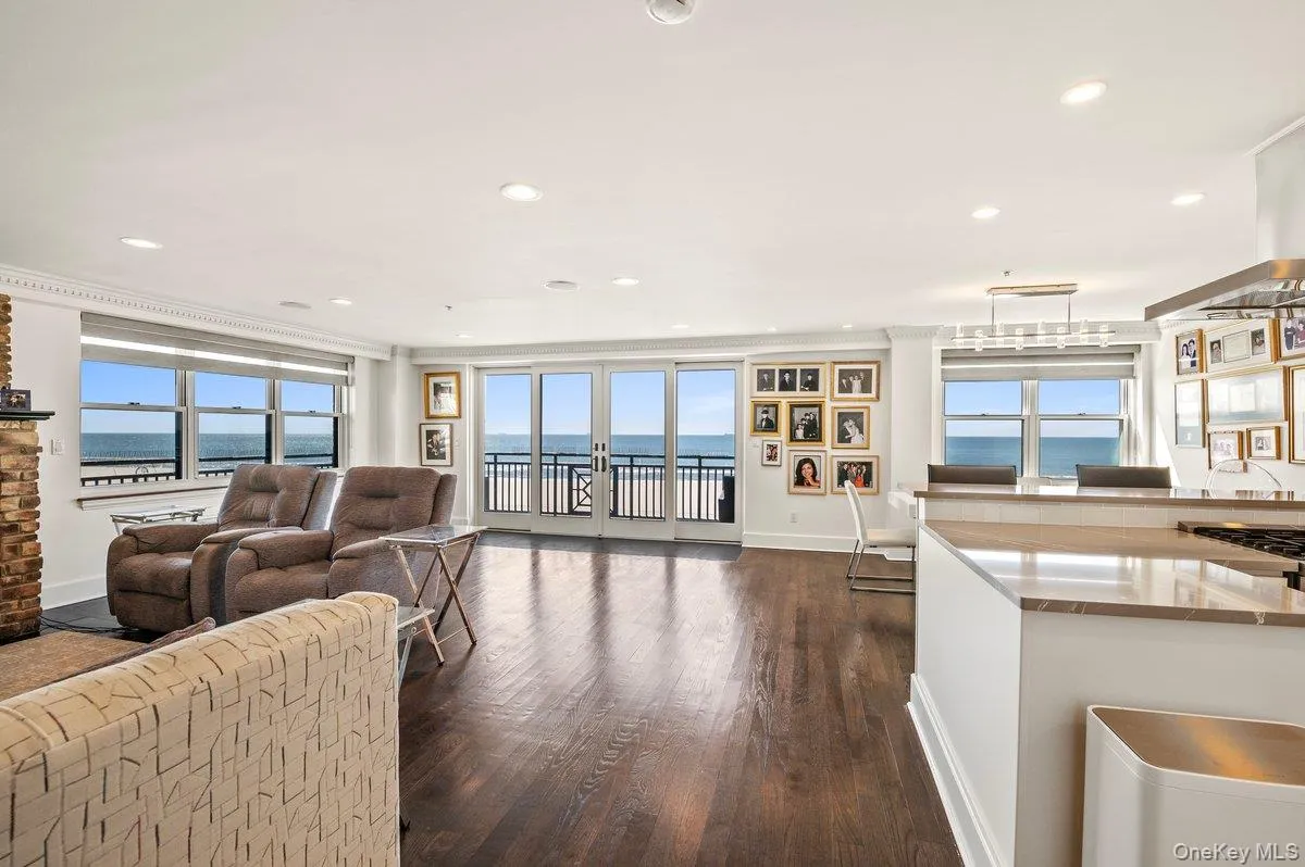 Living area featuring a water view, recessed lighting, baseboards, and dark wood finished floors Living area featuring a water view, recessed lighting, baseboards, and dark wood finished floors
