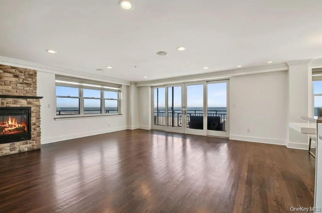 Unfurnished living room with a fireplace, dark wood-style floors, and recessed lighting Unfurnished living room with a fireplace, dark wood-style floors, and recessed lighting