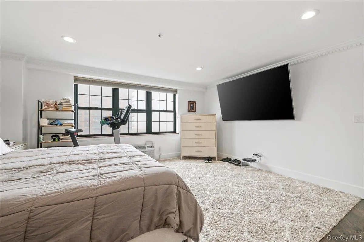 Bedroom featuring baseboards, wood finished floors, recessed lighting, and crown molding Bedroom featuring baseboards, wood finished floors, recessed lighting, and crown molding