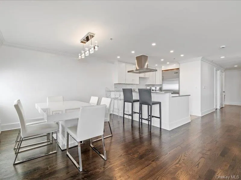 Dining space featuring dark wood-style flooring, ornamental molding, baseboards, and recessed lighting Dining space featuring dark wood-style flooring, ornamental molding, baseboards, and recessed lighting