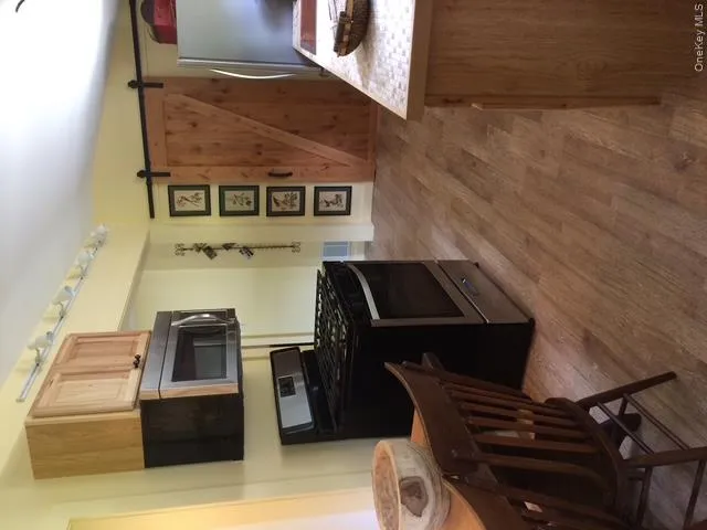 Kitchen with light brown cabinets, wood finished floors, stove, and fridge Kitchen with light brown cabinets, wood finished floors, stove, and fridge