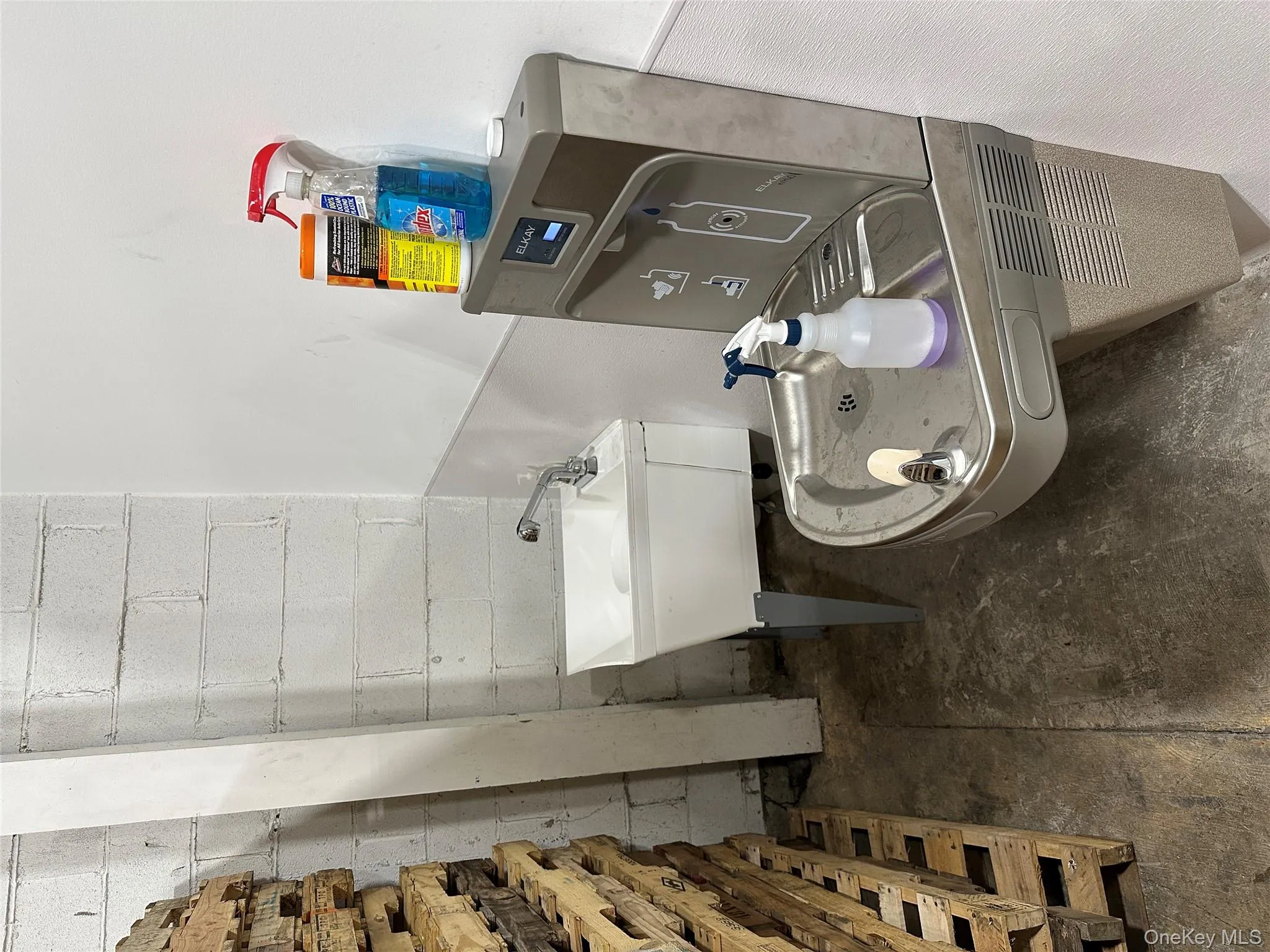 Bathroom featuring a sink, concrete floors, and concrete block wall Bathroom featuring a sink, concrete floors, and concrete block wall