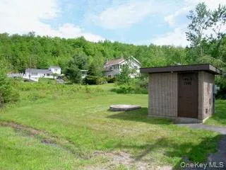 View of yard with a forest view, a storage unit, and an outdoor structure View of yard with a forest view, a storage unit, and an outdoor structure