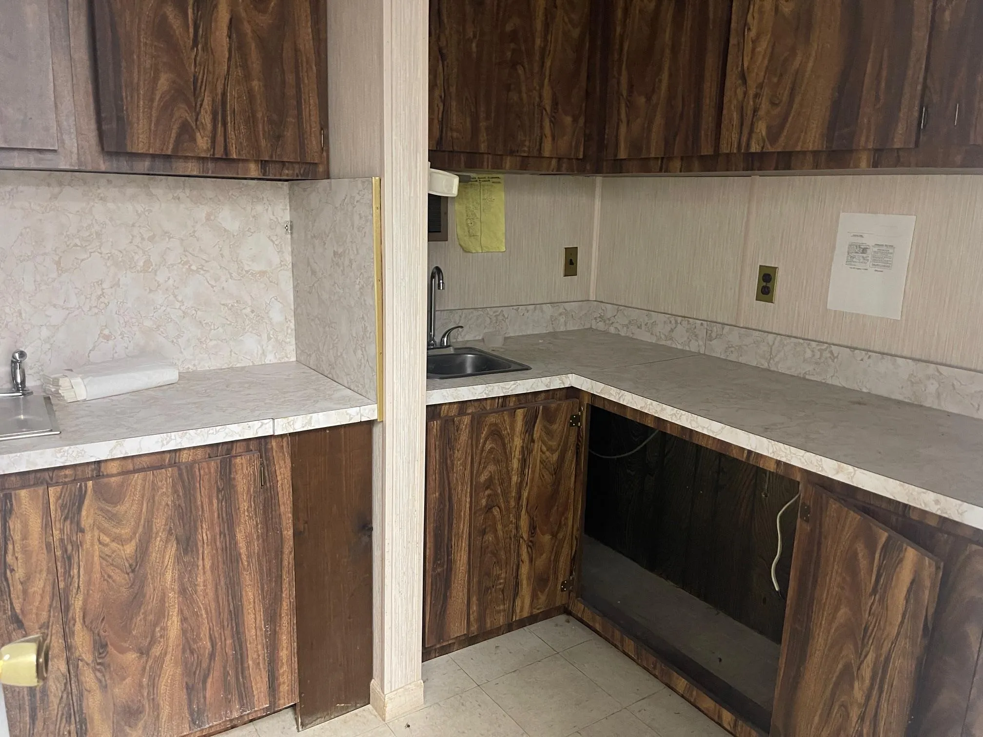 Kitchen featuring light countertops, decorative backsplash, a sink, and dark brown cabinetry Kitchen featuring light countertops, decorative backsplash, a sink, and dark brown cabinetry