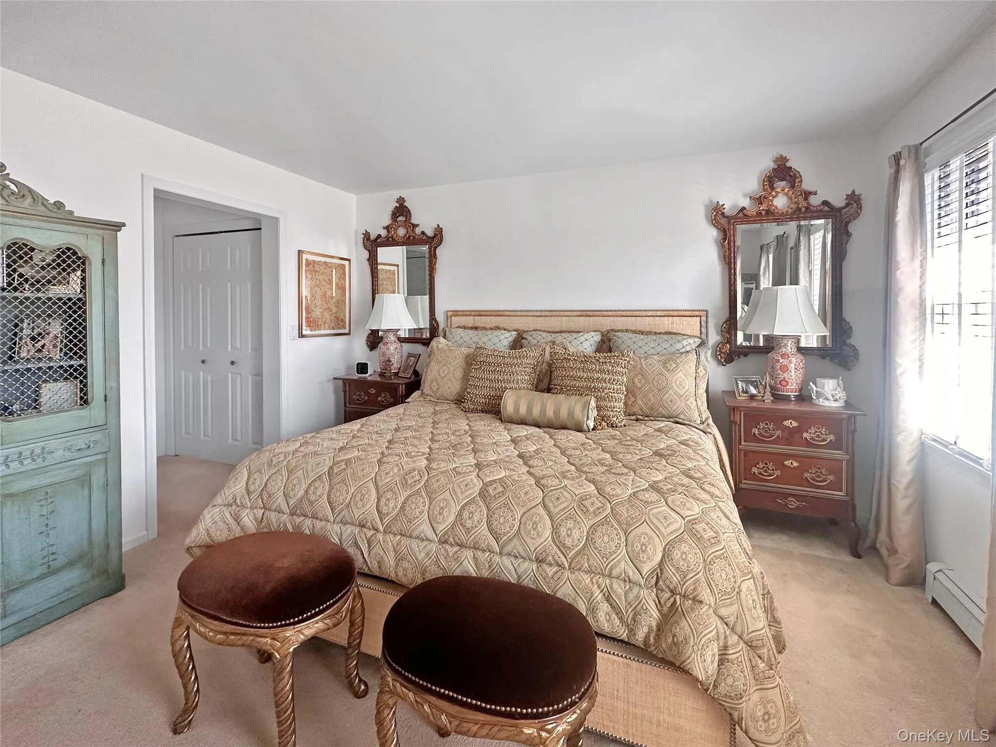 Bedroom with a baseboard radiator, a closet, and light colored carpet Bedroom with a baseboard radiator, a closet, and light colored carpet