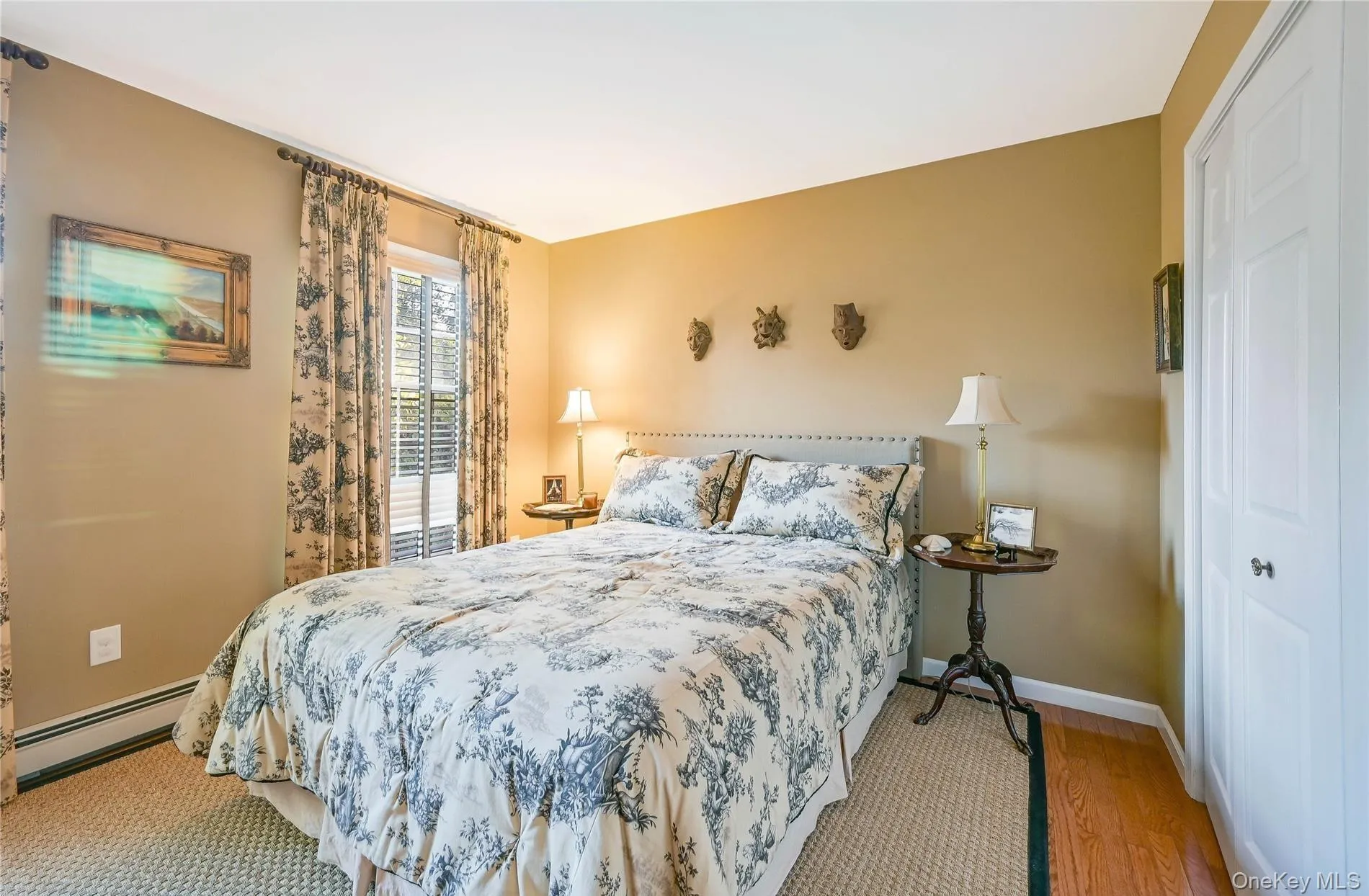 Bedroom with baseboards, wood finished floors, and baseboard heating Bedroom with baseboards, wood finished floors, and baseboard heating