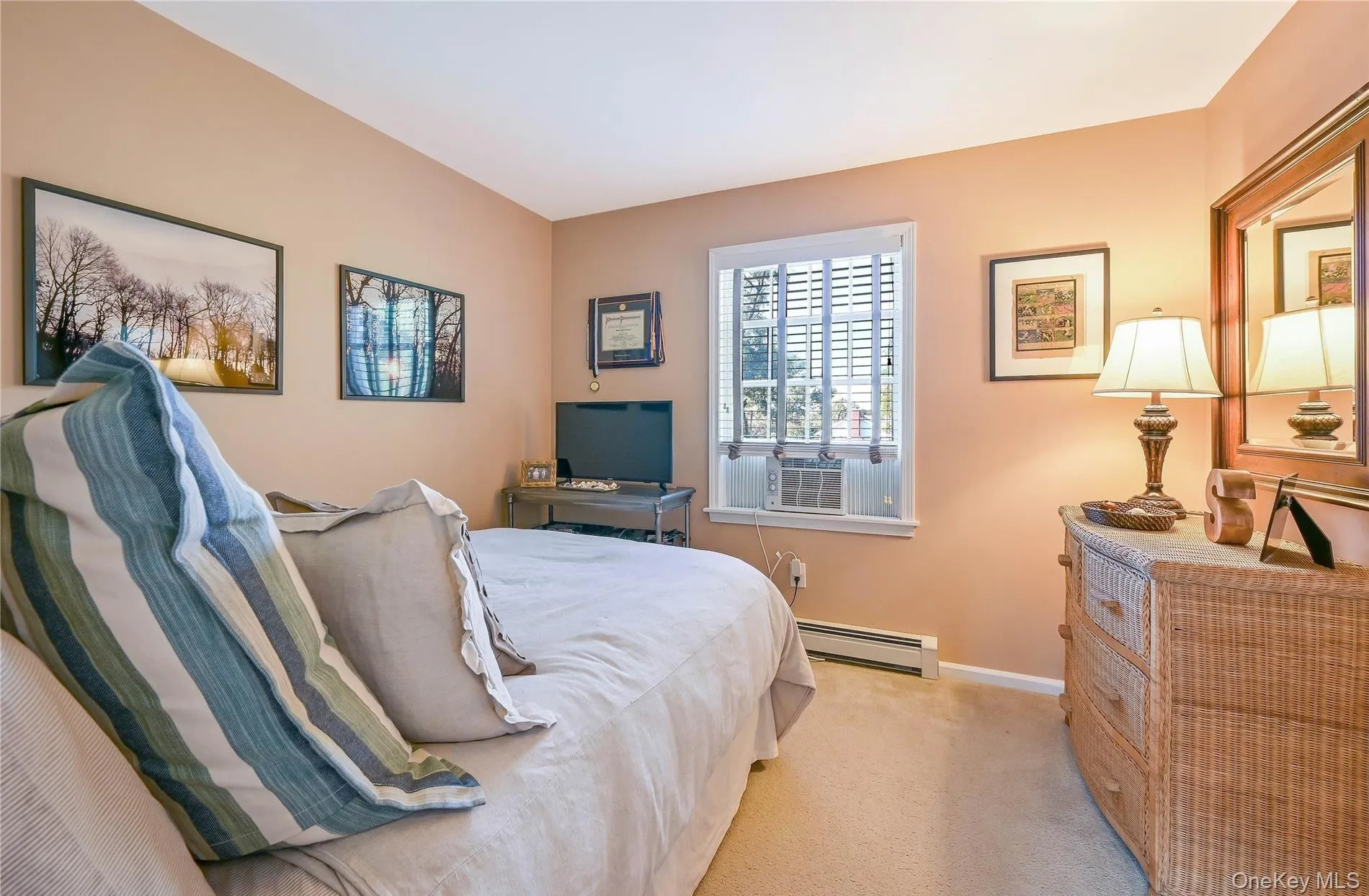 Carpeted bedroom featuring baseboards and a baseboard heating unit Carpeted bedroom featuring baseboards and a baseboard heating unit
