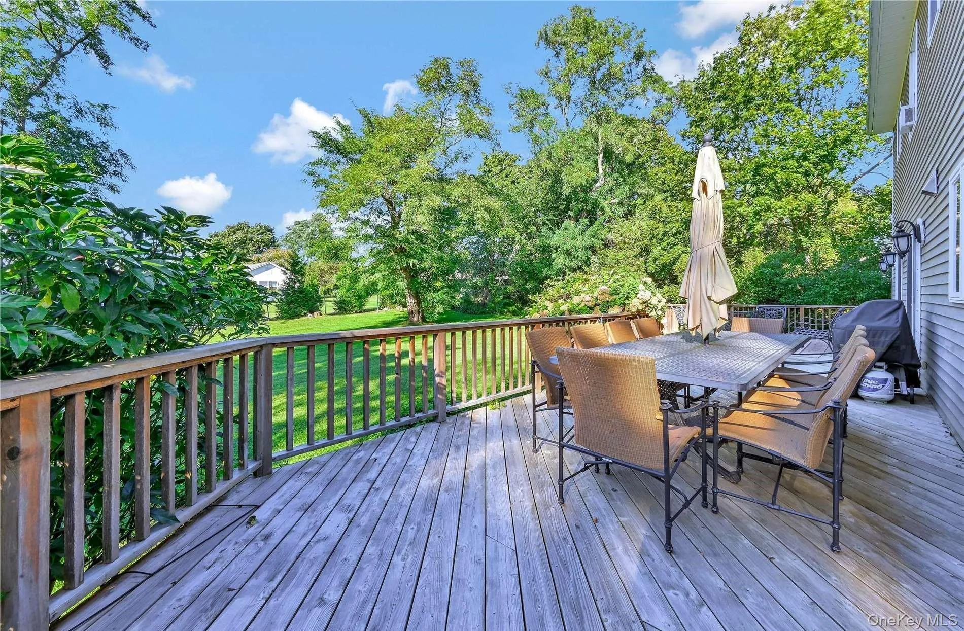 Wooden deck featuring grilling area, a yard, and outdoor dining space Wooden deck featuring grilling area, a yard, and outdoor dining space