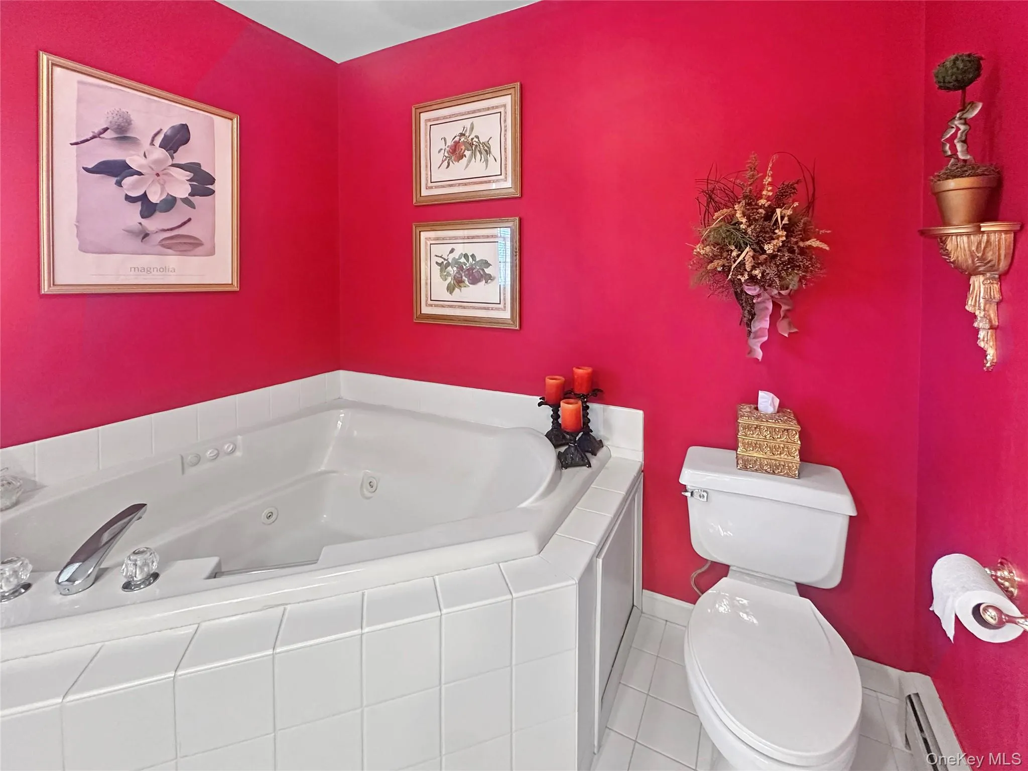 Bathroom with a tub with jets, toilet, and a baseboard heating unit Bathroom with a tub with jets, toilet, and a baseboard heating unit