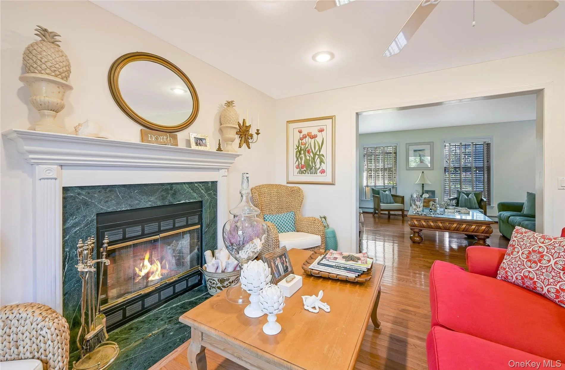 Living area featuring ceiling fan, a premium fireplace, and wood finished floors Living area featuring ceiling fan, a premium fireplace, and wood finished floors