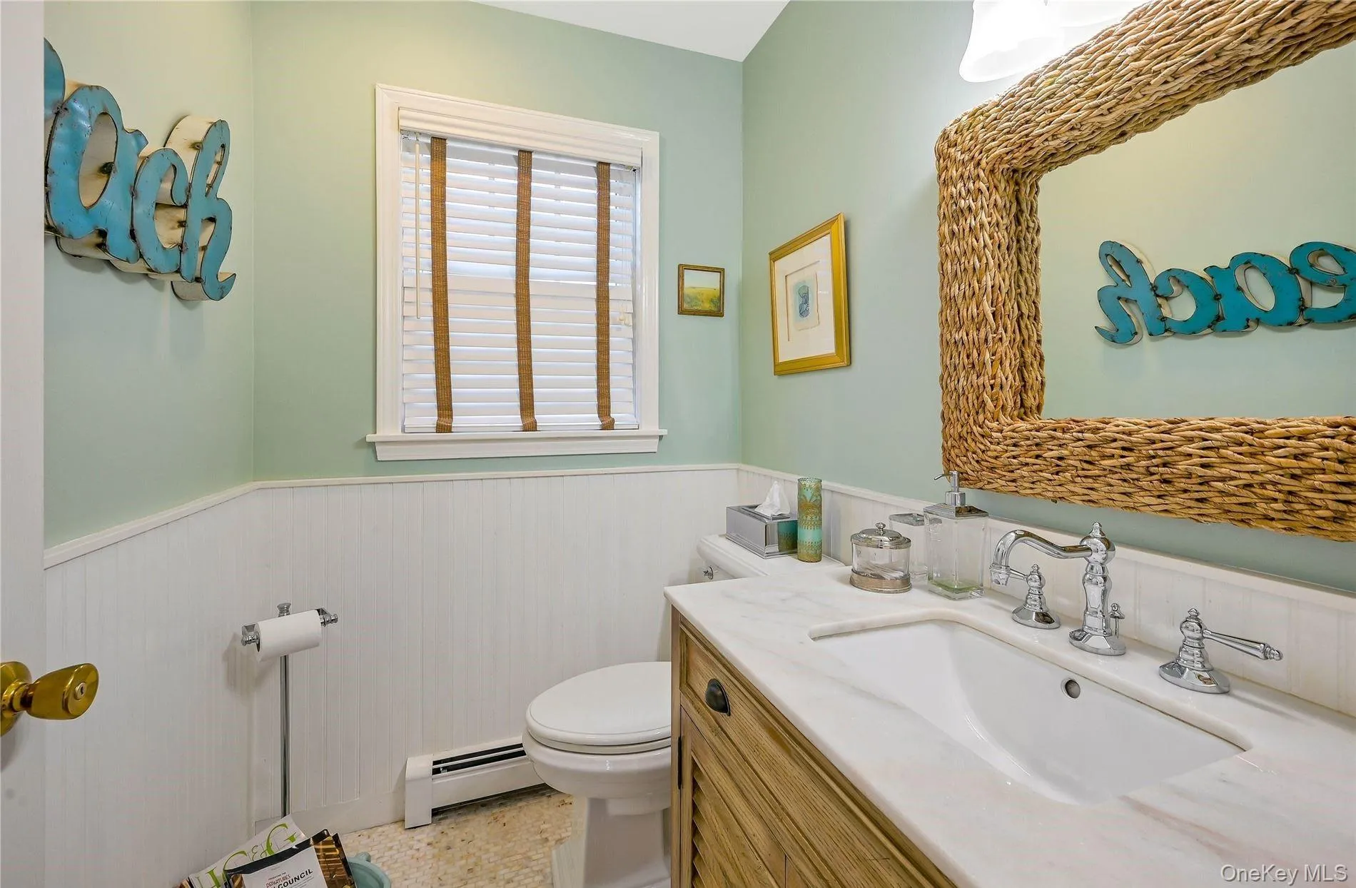 Half bathroom with vanity, toilet, a baseboard heating unit, and wainscoting Half bathroom with vanity, toilet, a baseboard heating unit, and wainscoting