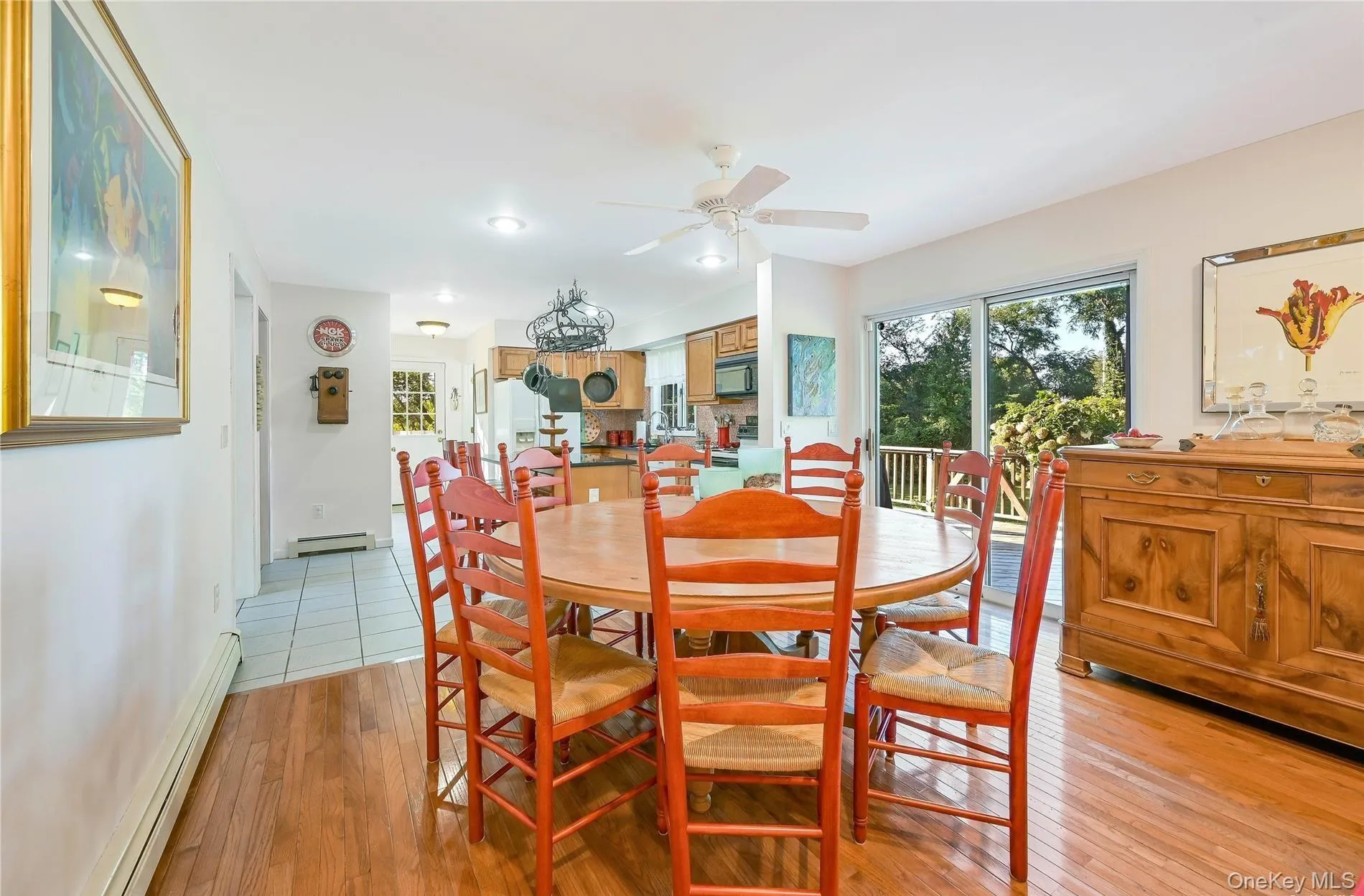 Dining space featuring a ceiling fan, light wood-style flooring, baseboard heating, and plenty of natural light Dining space featuring a ceiling fan, light wood-style flooring, baseboard heating, and plenty of natural light